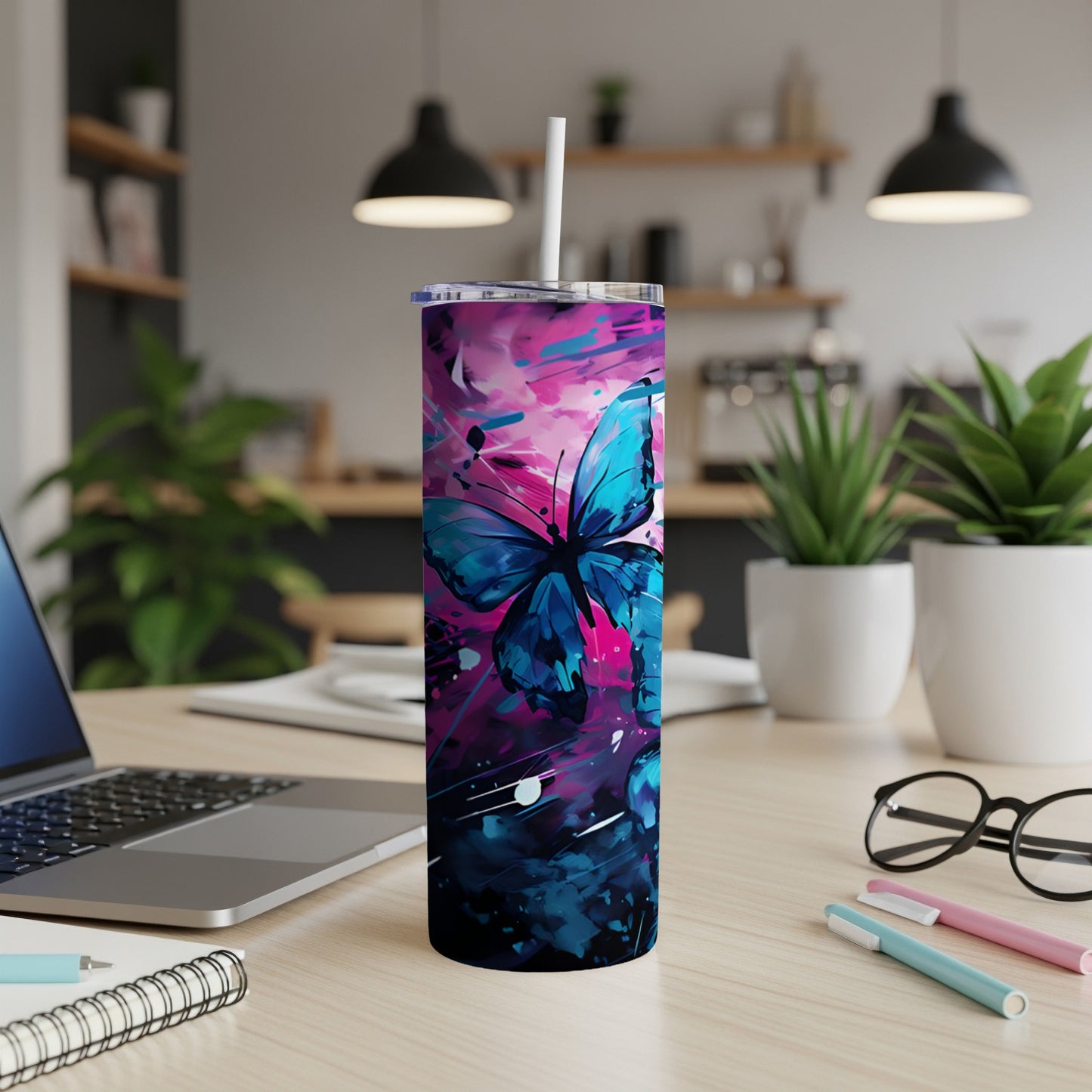 Blue butterfly on abstract pink and blue splatter pattern tumbler.
