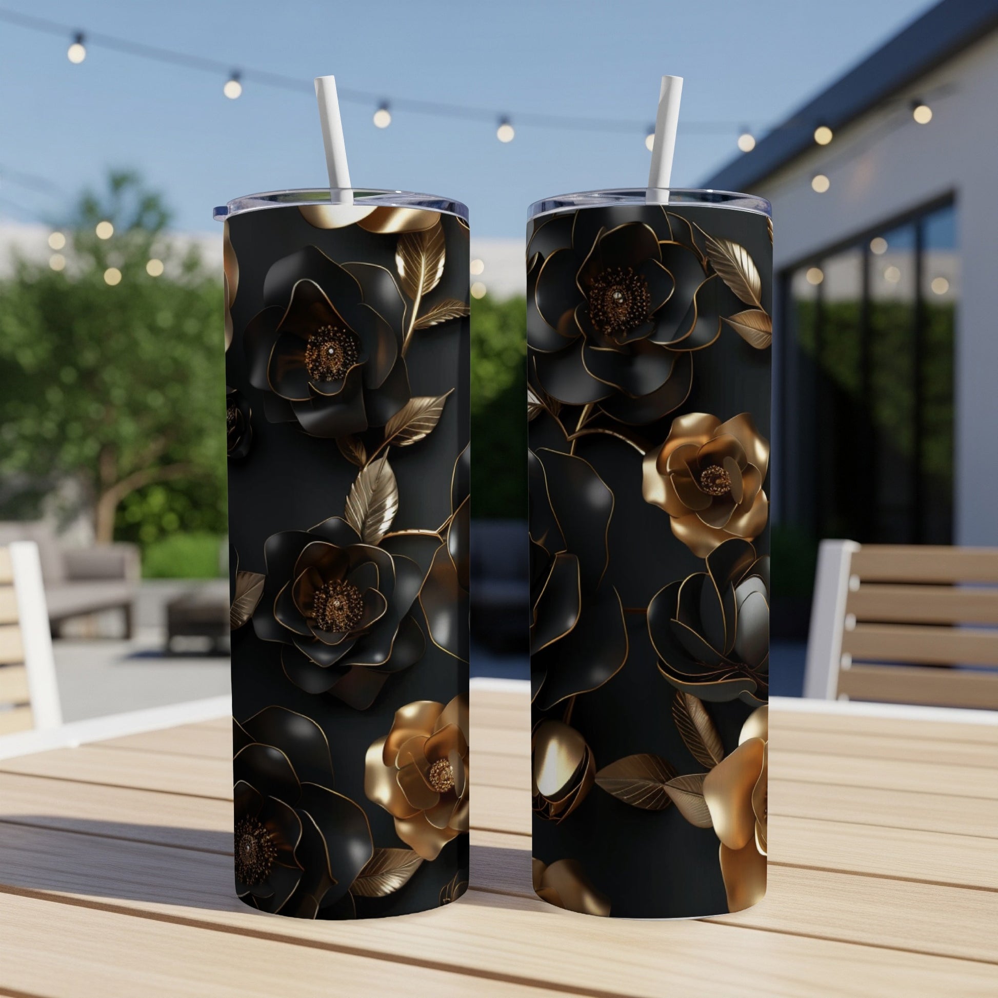 Two black tumblers with gold and black floral designs sit on a wooden table.