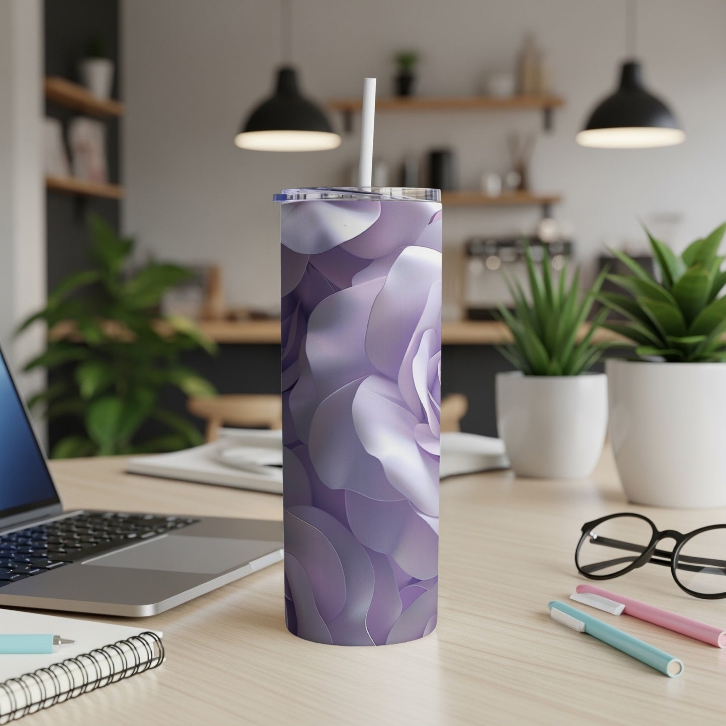 Purple floral pattern tumbler with straw on a desk.