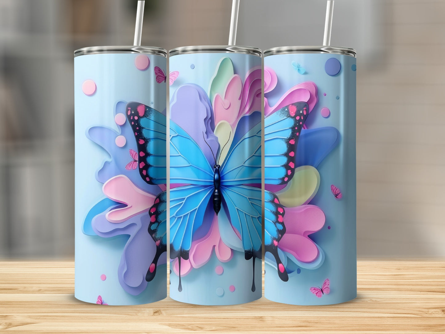 Three tumblers with blue butterflies and colorful floral elements.