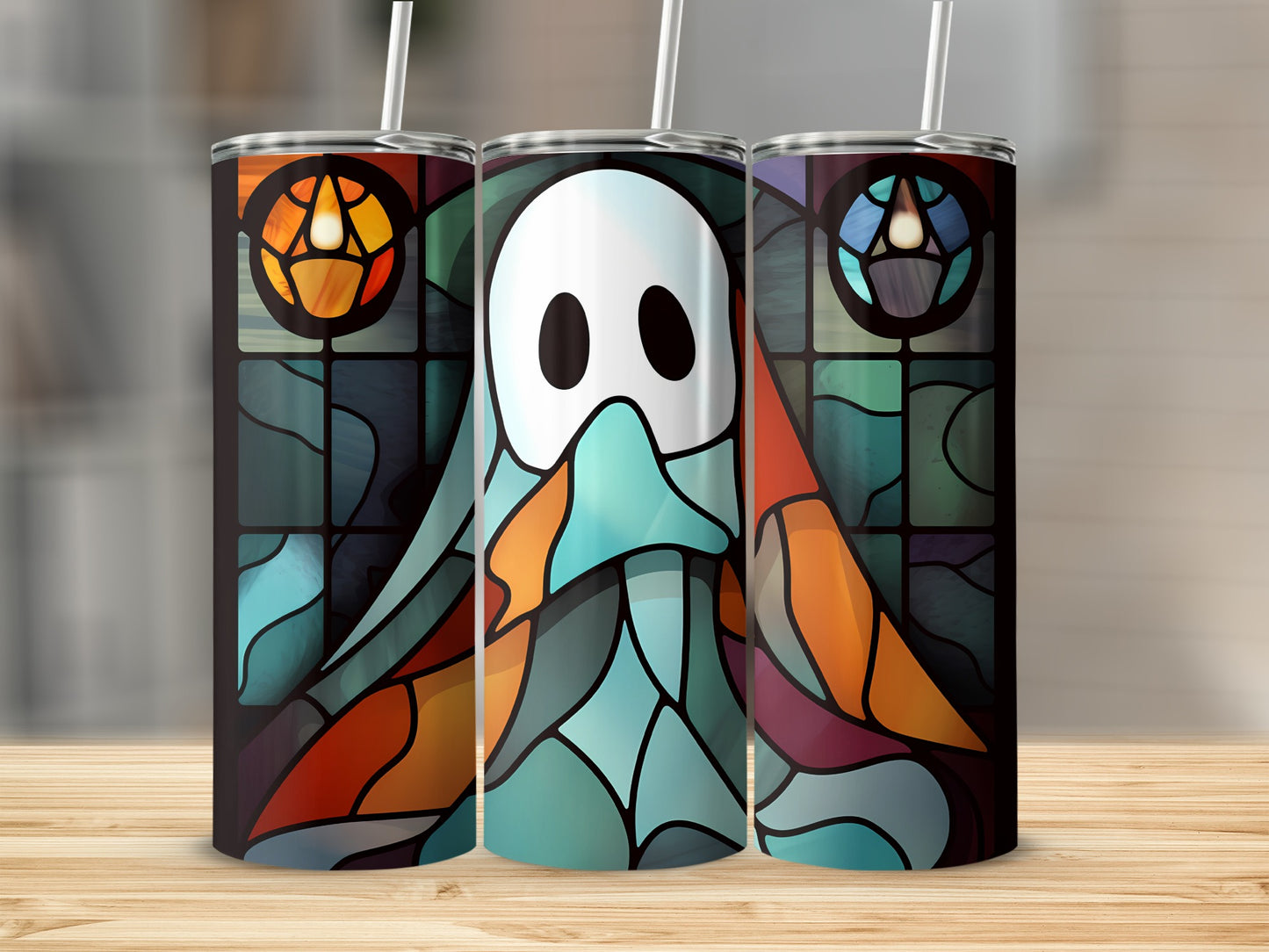 Ghost stained glass design on three tumblers on a wooden surface.