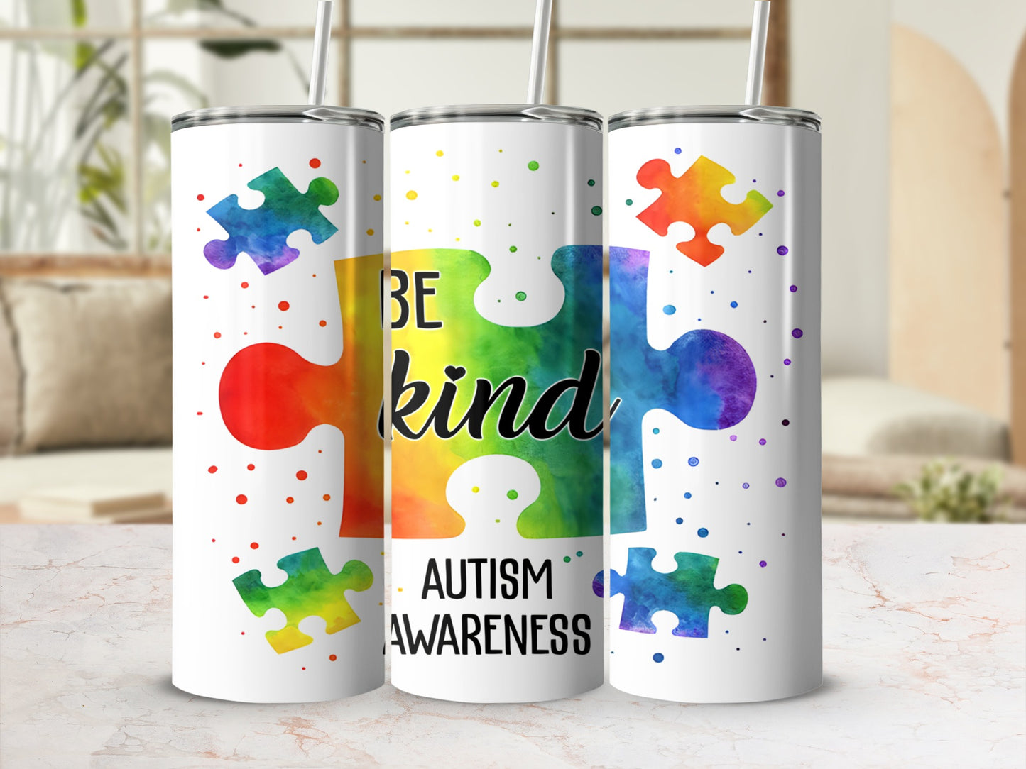 White tumbler with "Be Kind" and rainbow puzzle pieces for Autism Awareness.