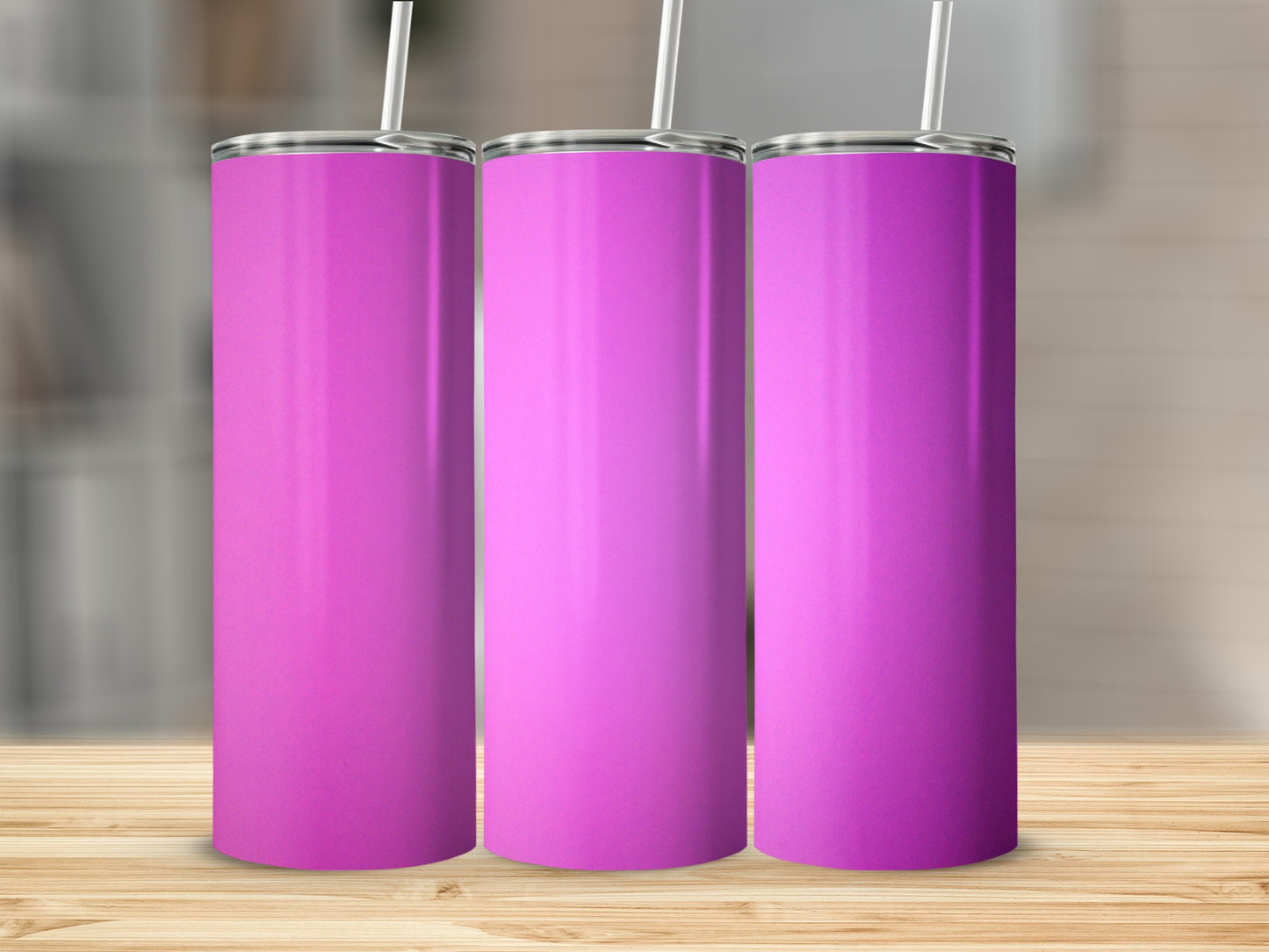 Three plain pink tumblers with straws stand on a wooden surface.