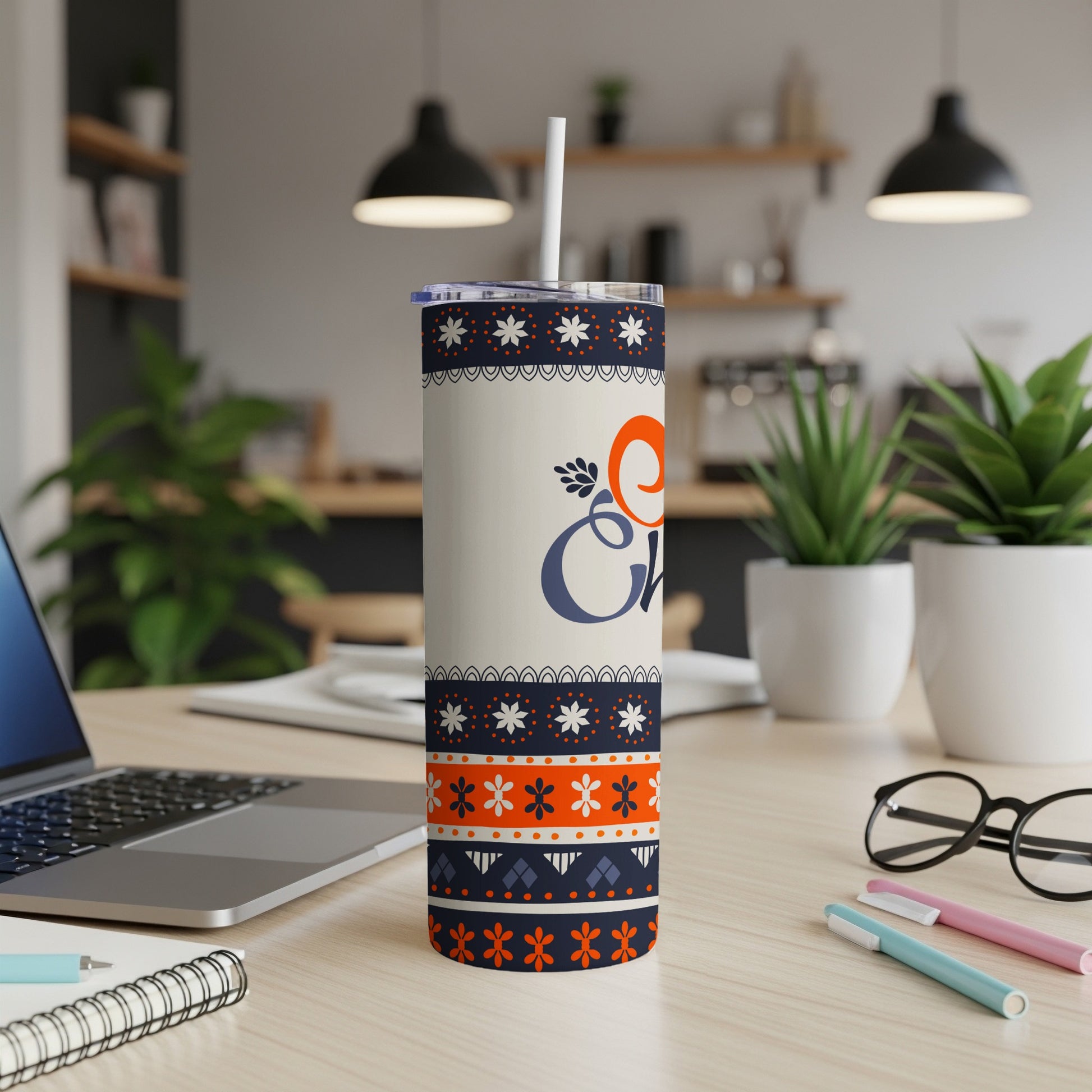 White tumbler with orange and blue "Cheer" text and snowflake design.