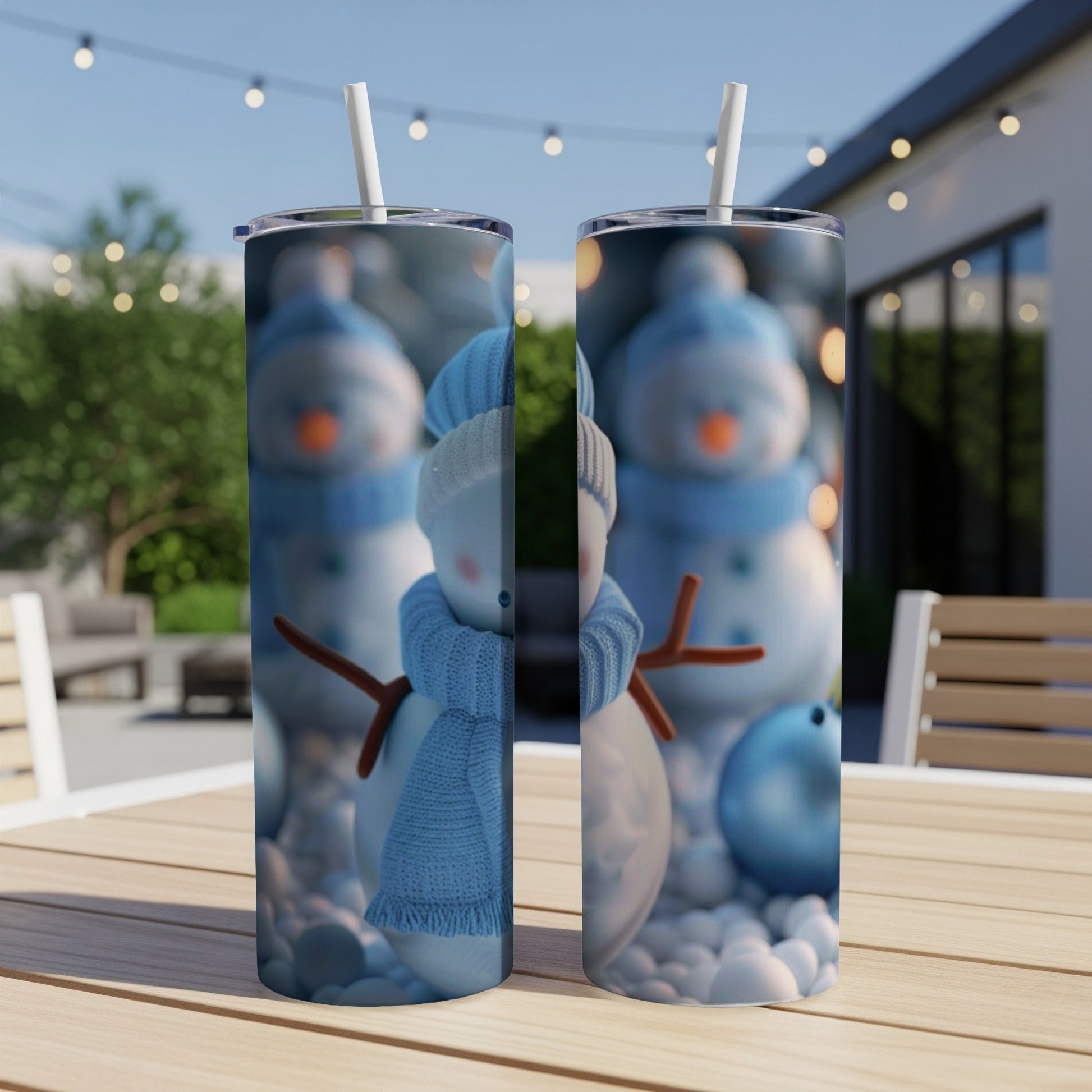 Two tumblers with a blue scarf snowman design on a table.
