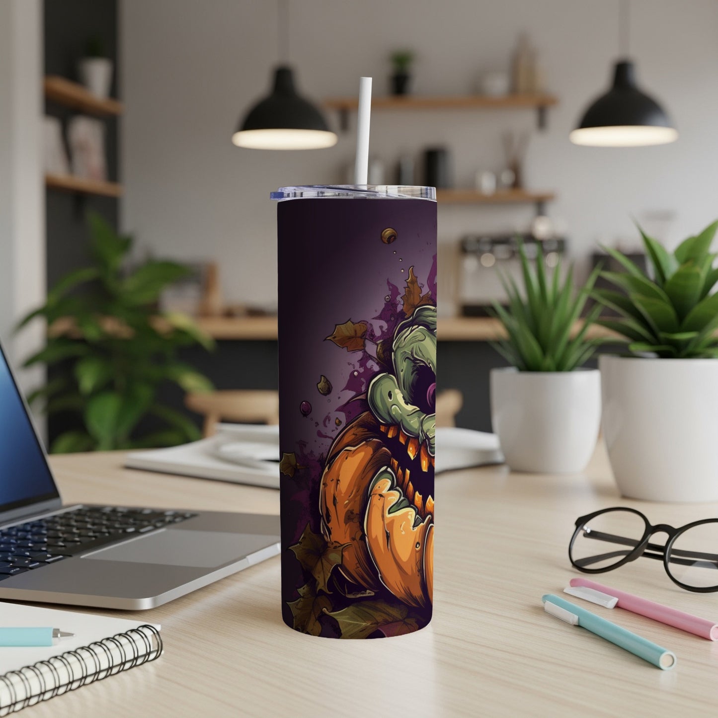 Tall tumbler with a spooky green monster emerging from a jack-o'-lantern and autumn leaves.