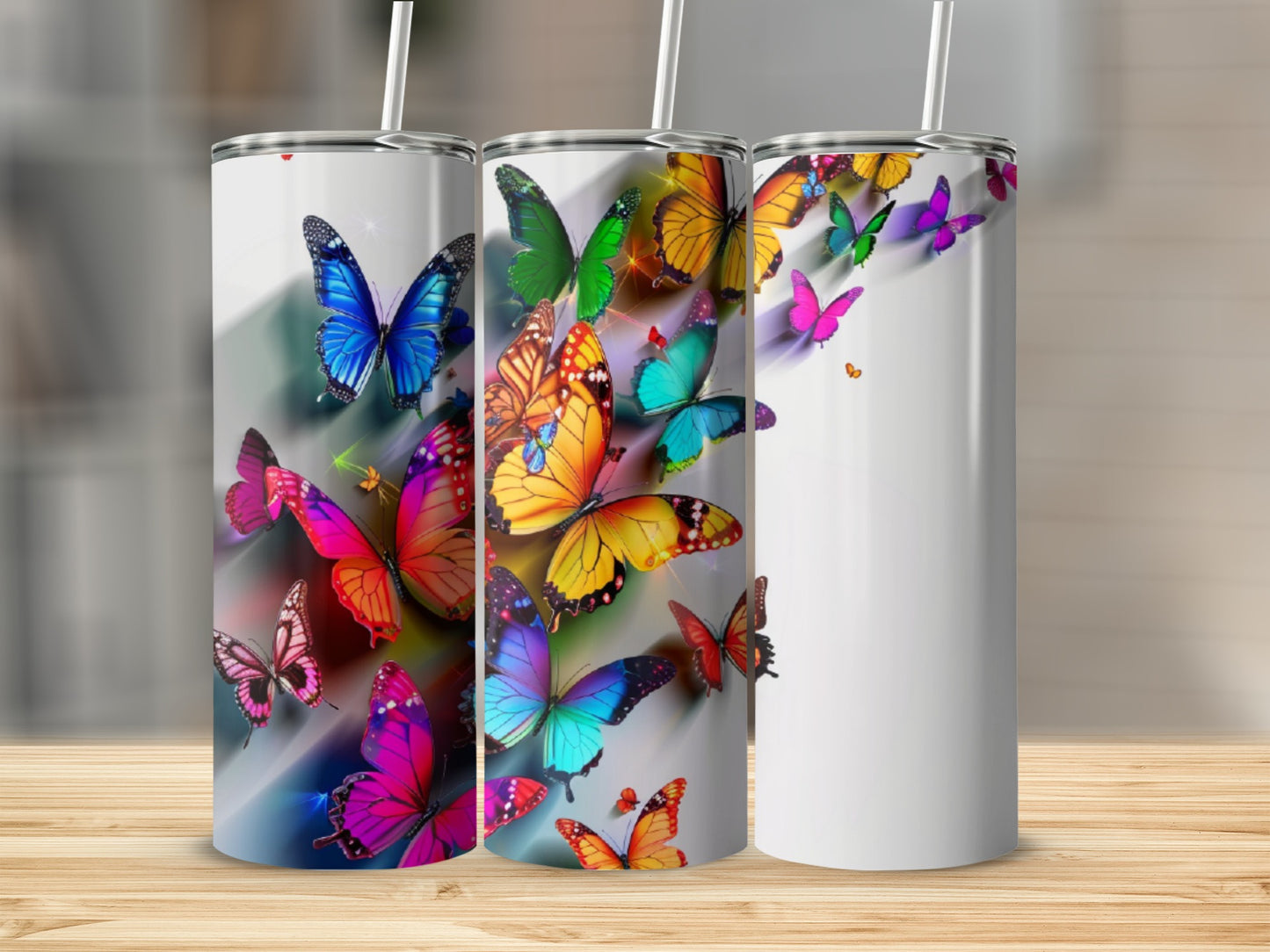 Three stainless steel tumblers with vibrant butterfly designs.