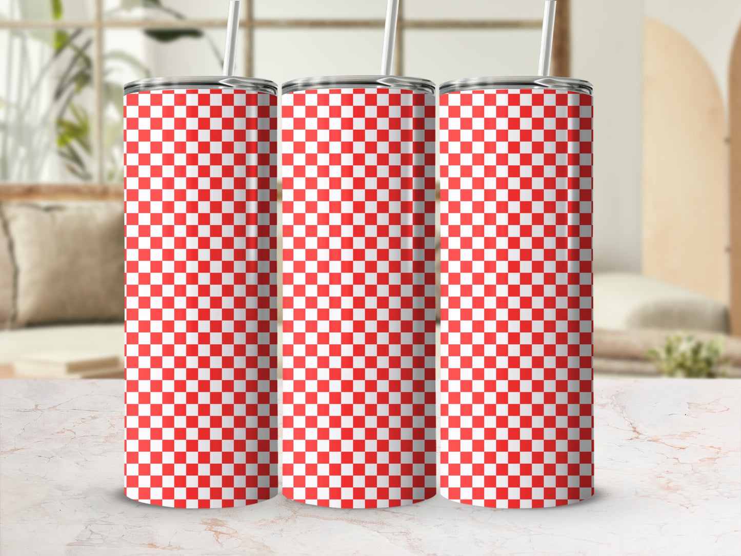 Three red and white checkered tumblers with straws on a marble surface.