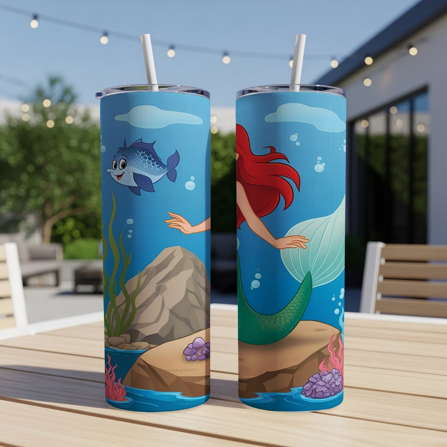Two mermaid tumblers with cartoon fish, seaweed, and rocks against a blue background.