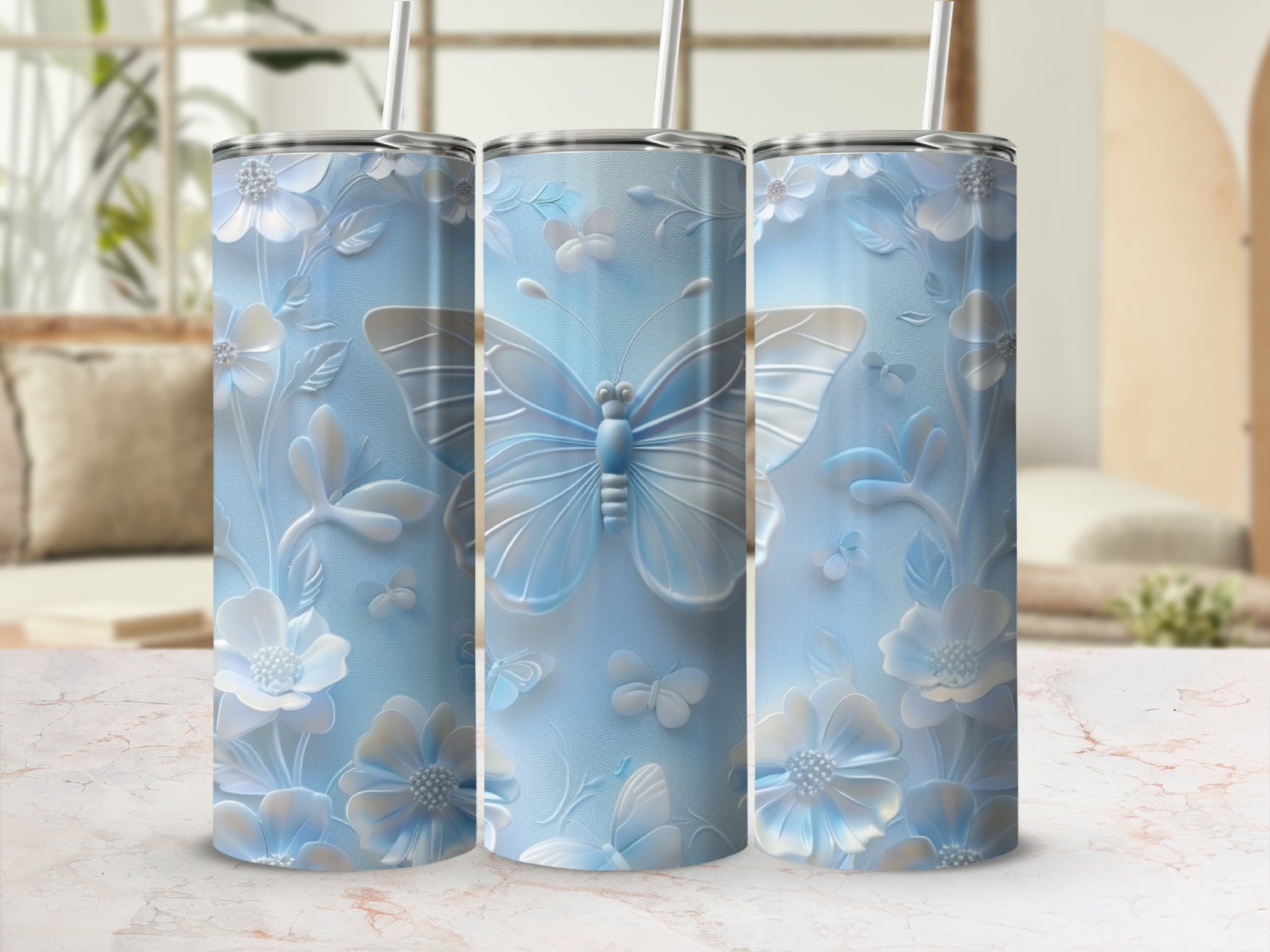 Three light blue tumblers with floral and butterfly embossed designs.