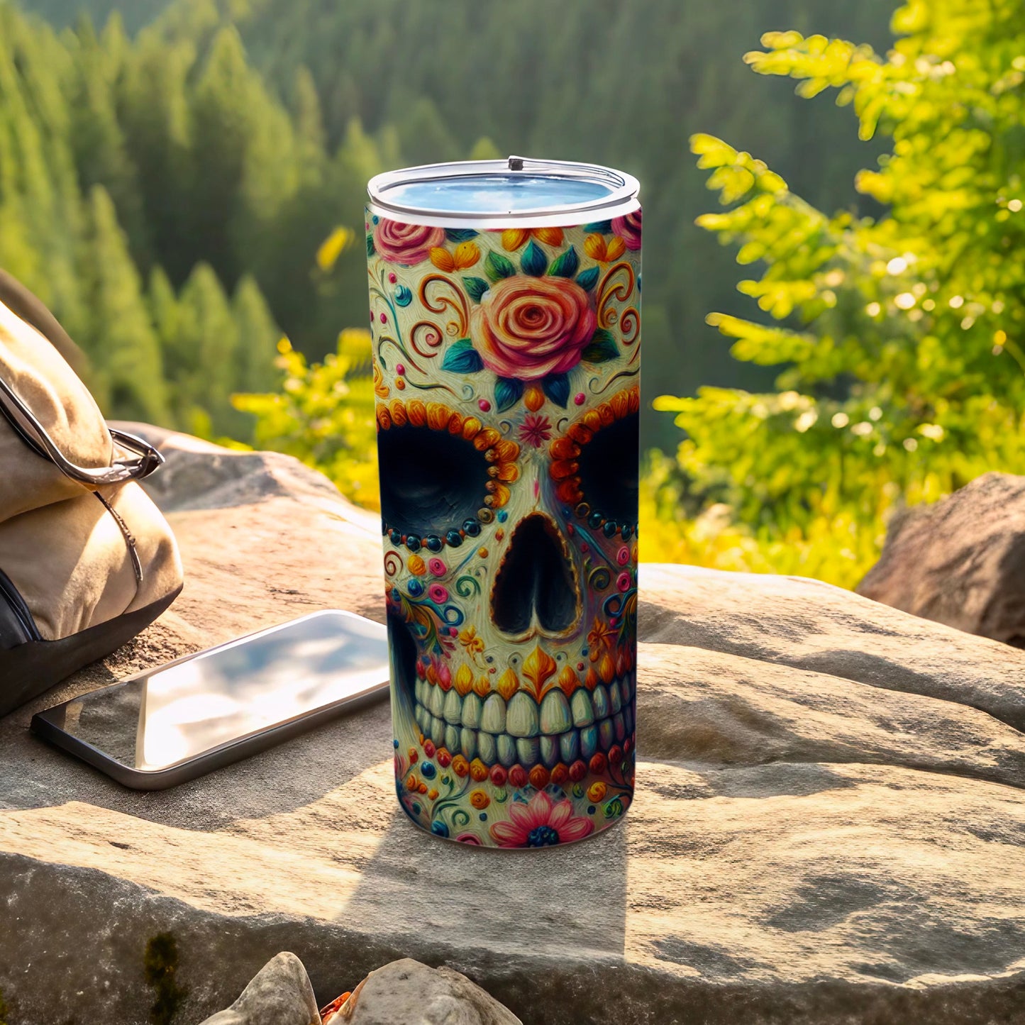 Sugar skull tumbler with floral accents on a rock.