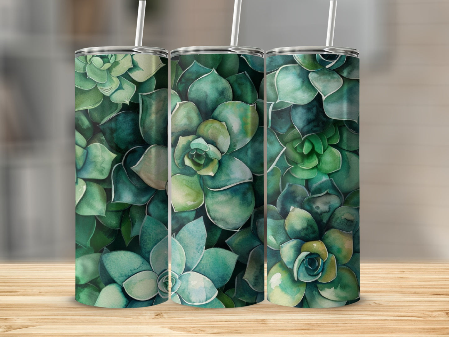Three tumblers with a green succulent pattern on a wooden surface.