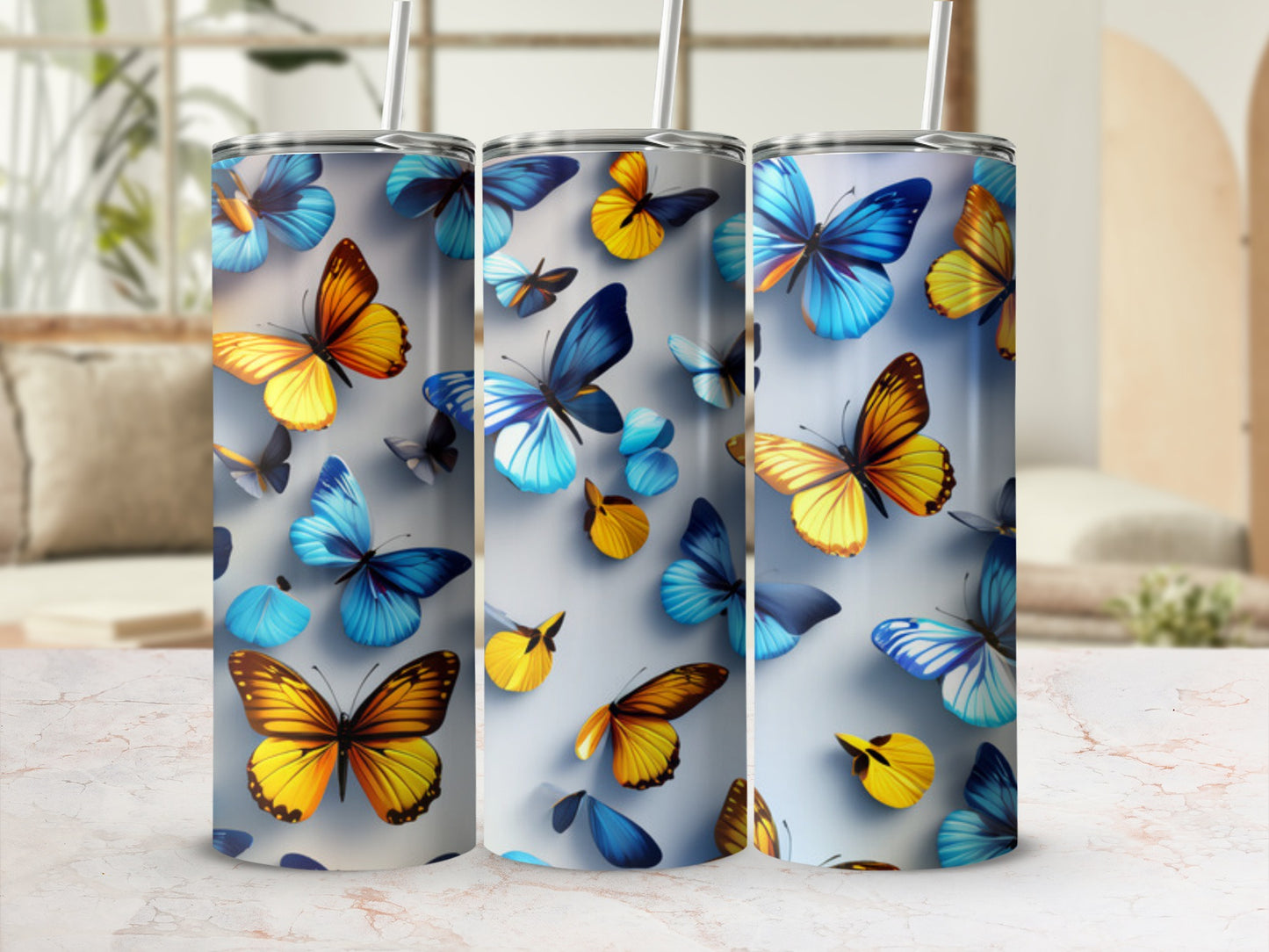 Three tumblers decorated with colorful butterflies in shades of blue, yellow, and orange.