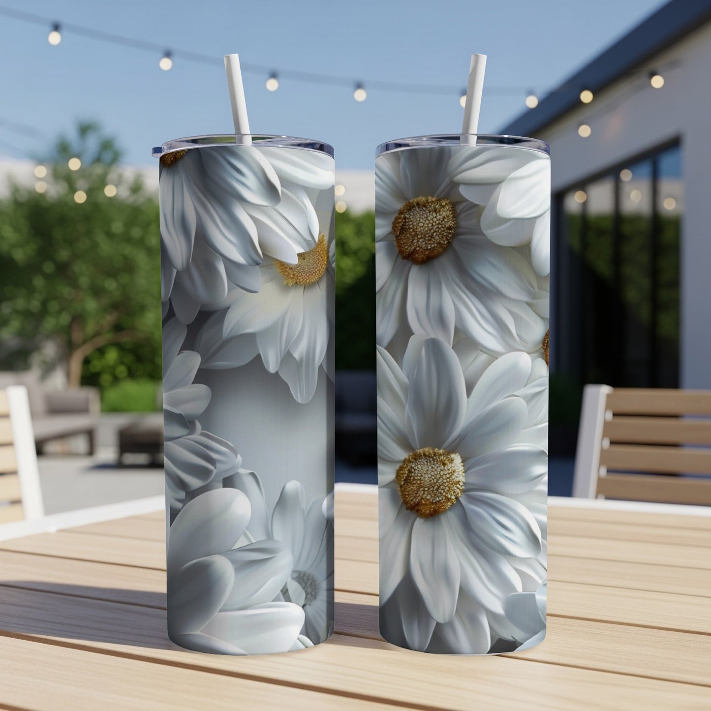White daisy floral pattern on two tumblers with straws on a table.