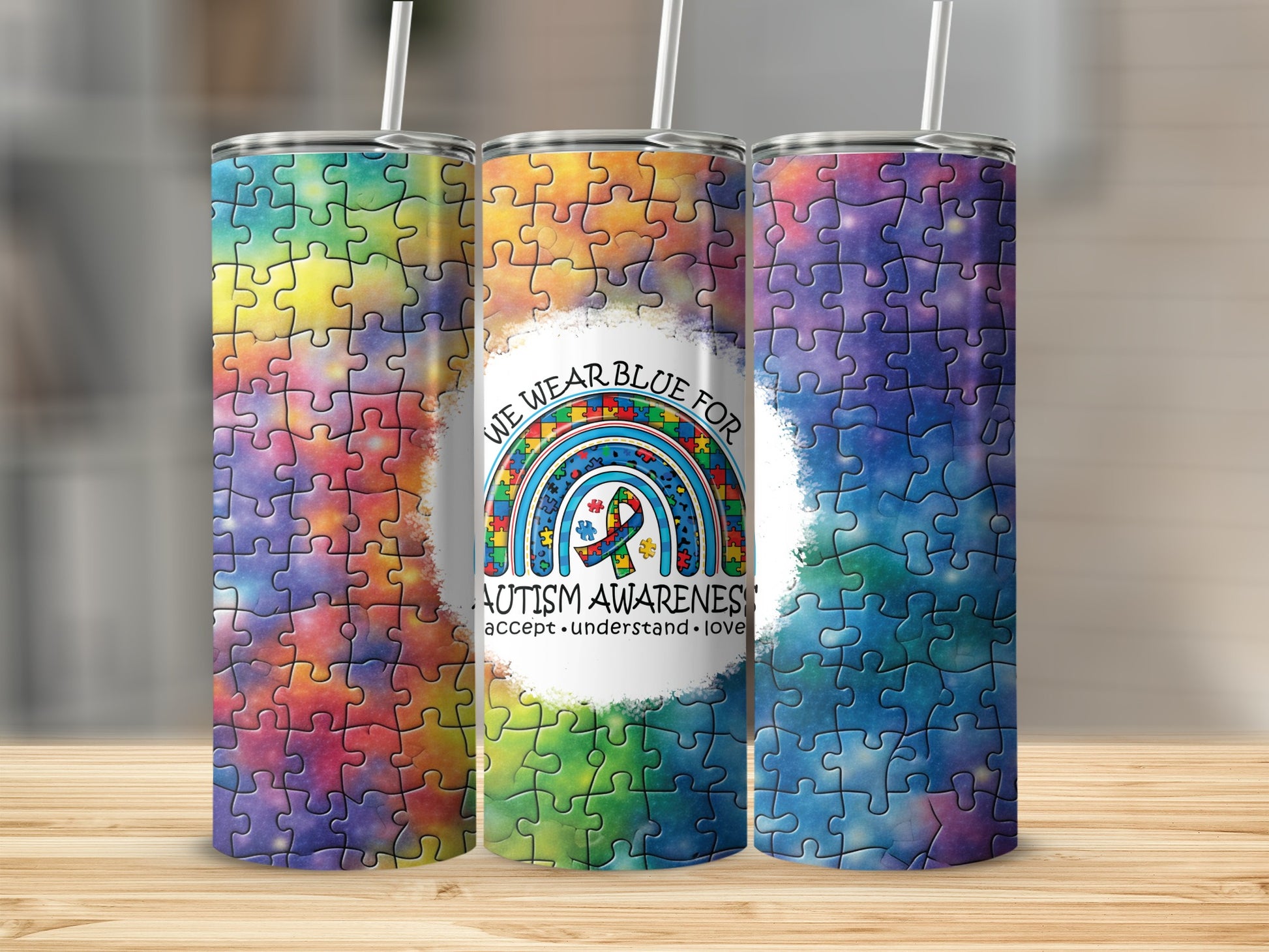 Three tumblers with a blue autism awareness ribbon and puzzle pieces.