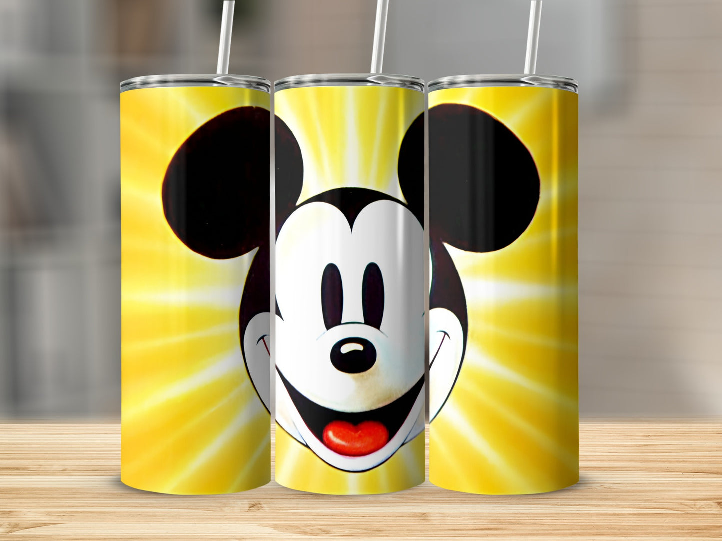 Mickey Mouse face with radiating yellow background on three tumblers.