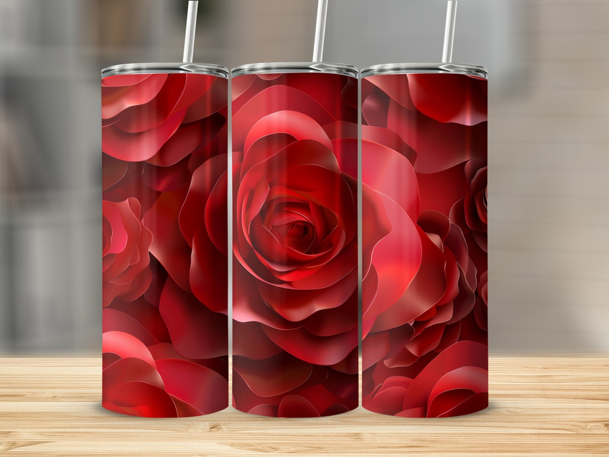 Three red rose tumblers with straws on a wooden surface.