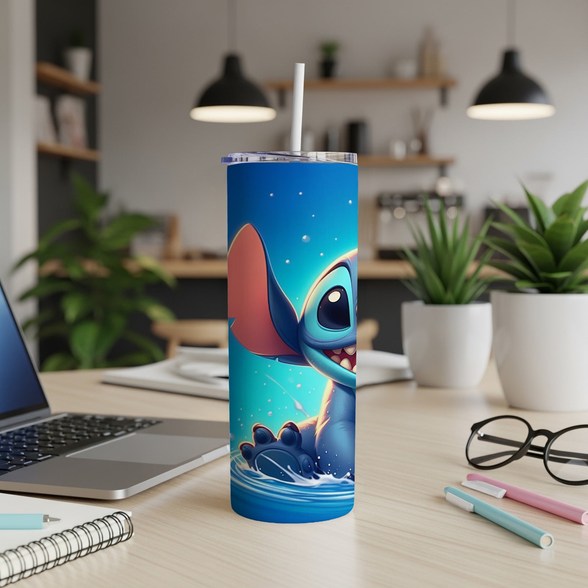 Stitch character in a blue tumbler cup with a straw, on a desk.