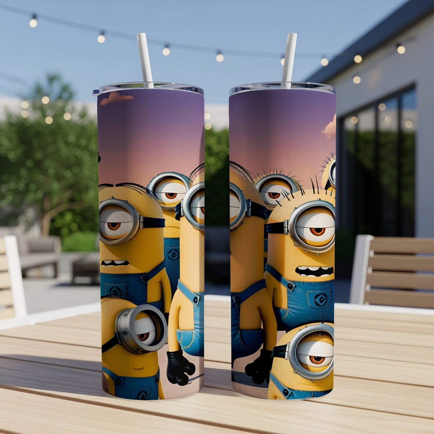 Two Minions tumblers with straws on a wooden table outdoors.