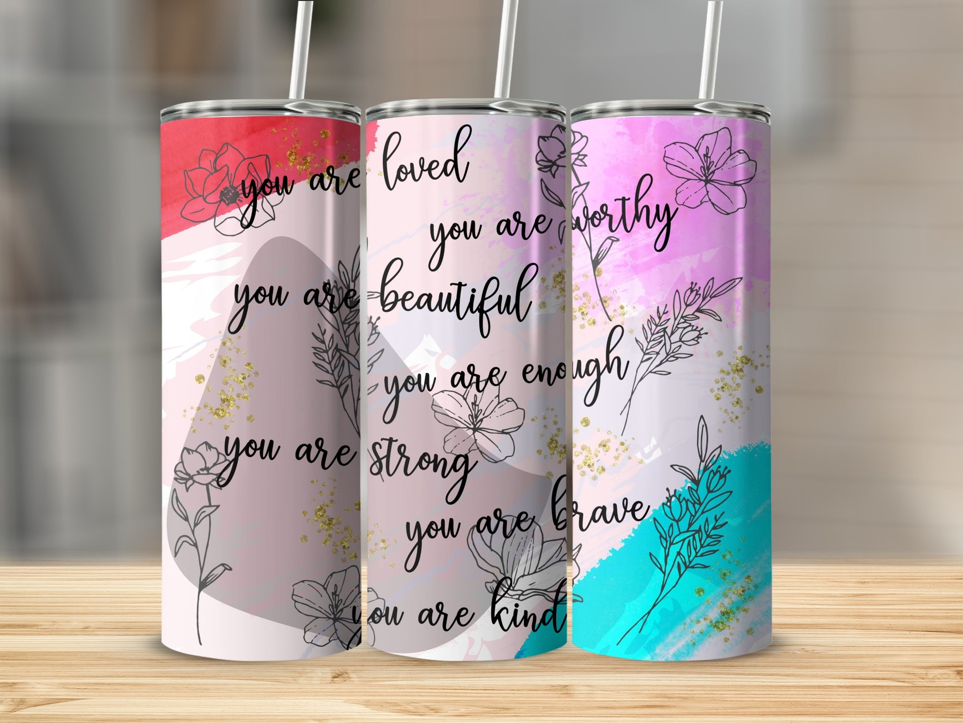 Three tumblers with floral designs and inspirational quotes "you are loved."