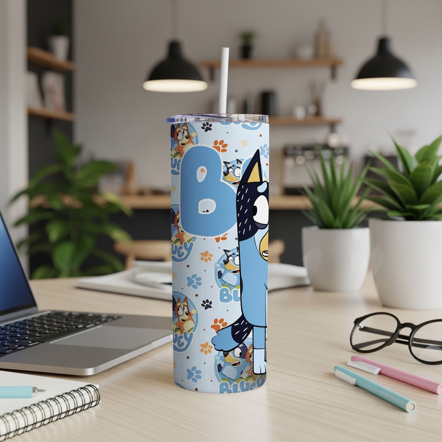 Bluey character pattern on a tall, blue tumbler with a straw.
