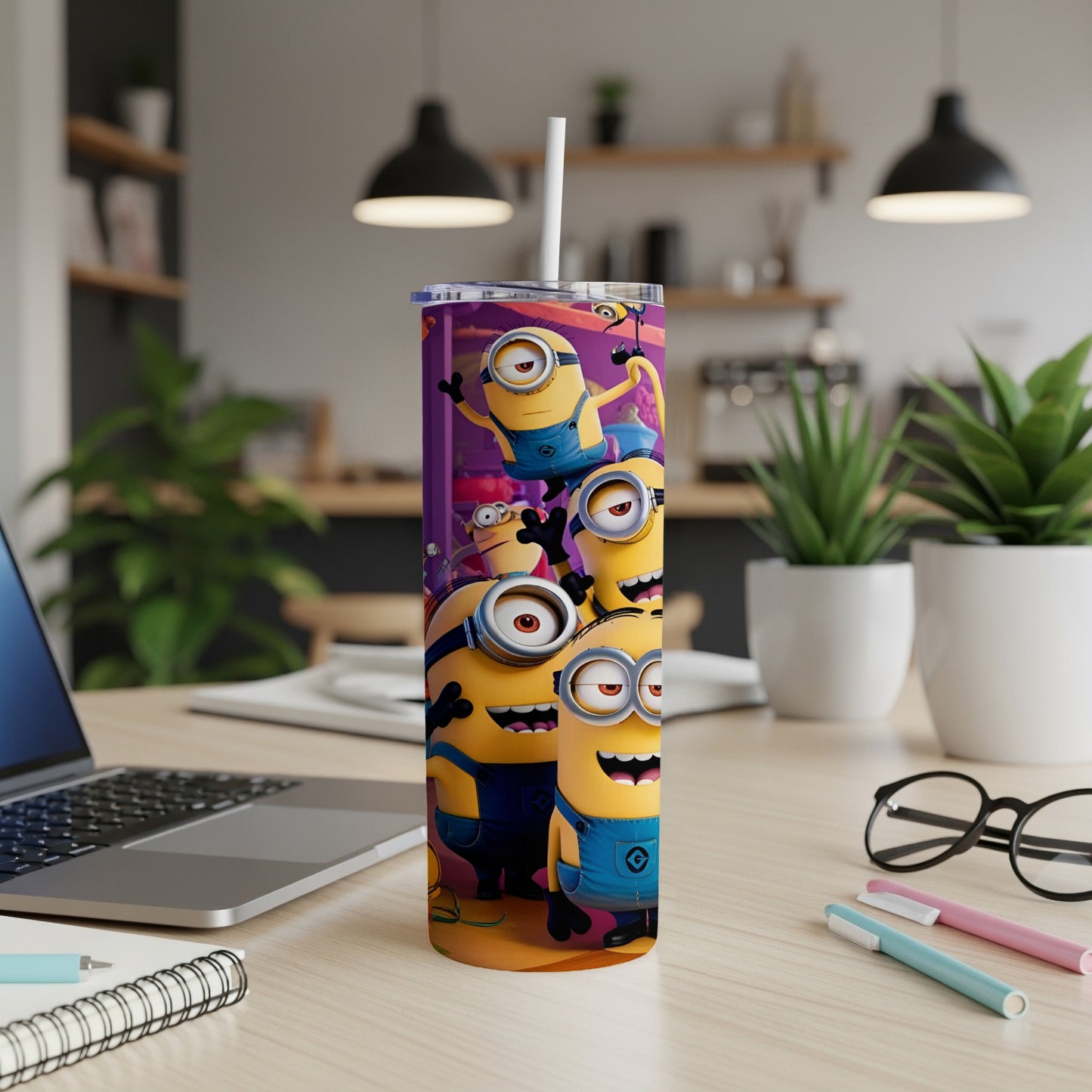 Minions characters on a purple tumbler with a straw on a desk.