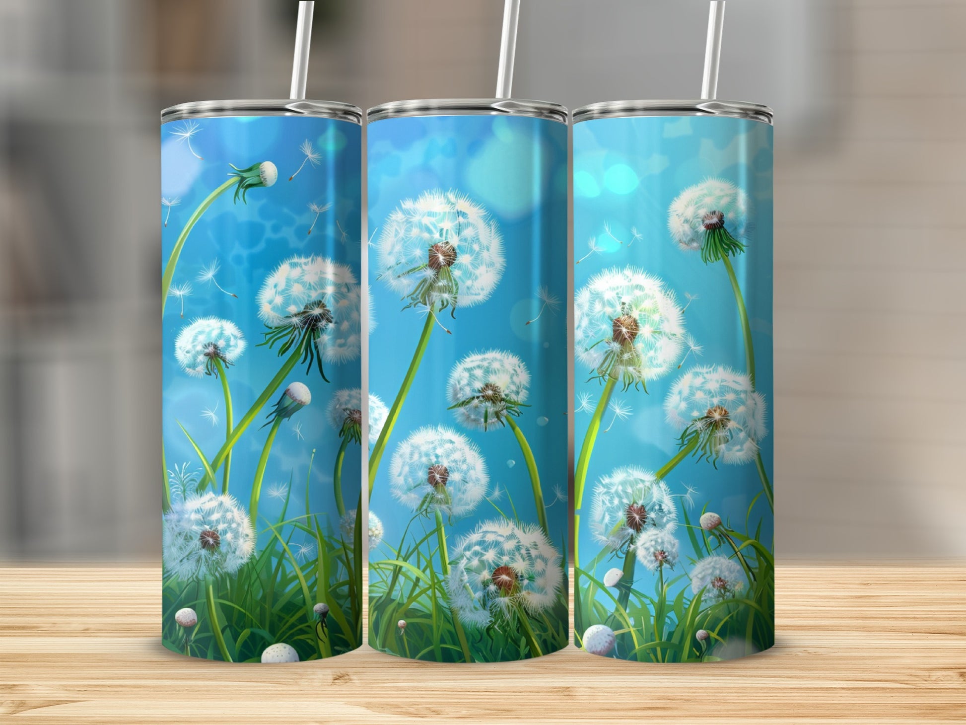 Three tumblers with a dandelion seed head design against a blue sky.