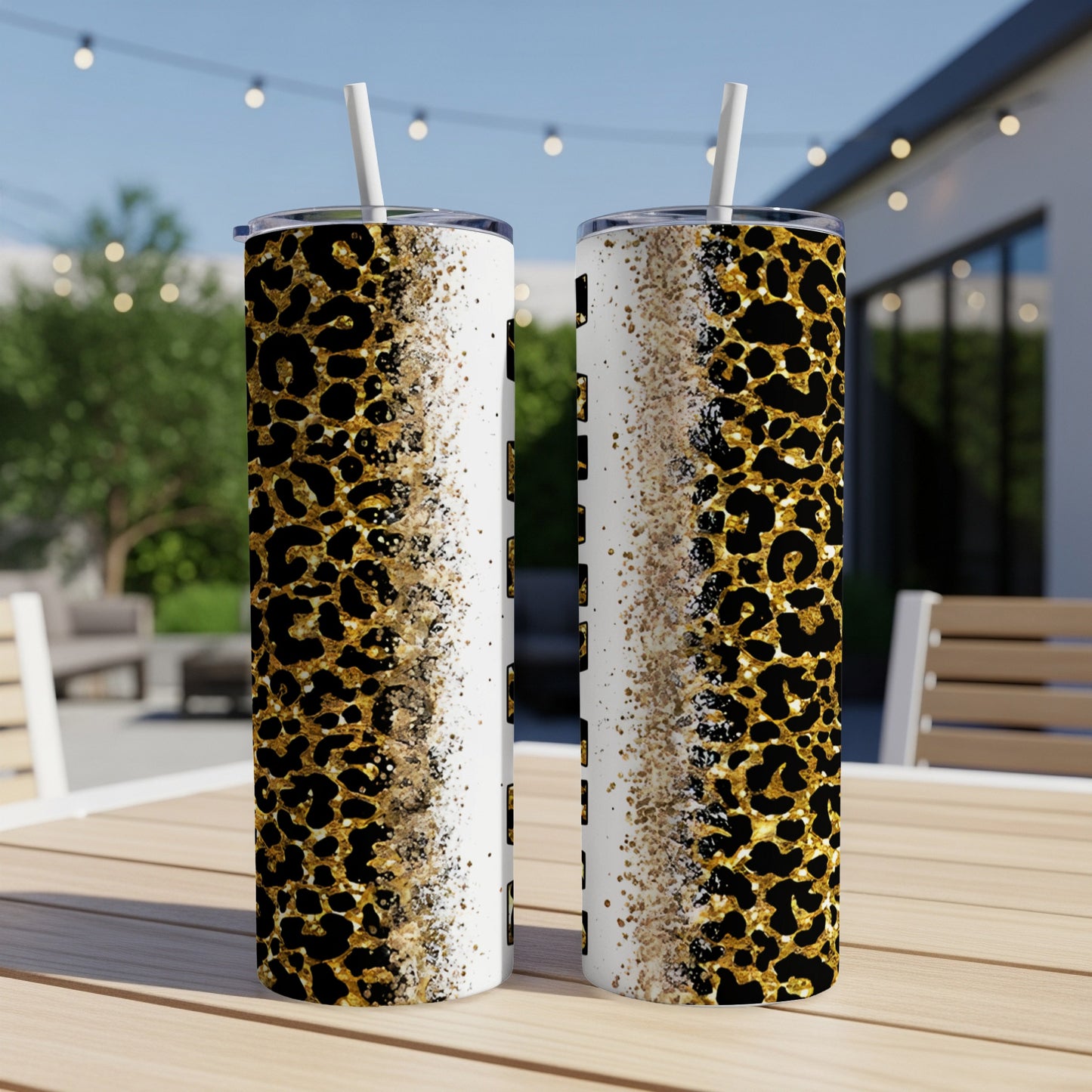 Two leopard print tumblers with gold glitter accents on a table.