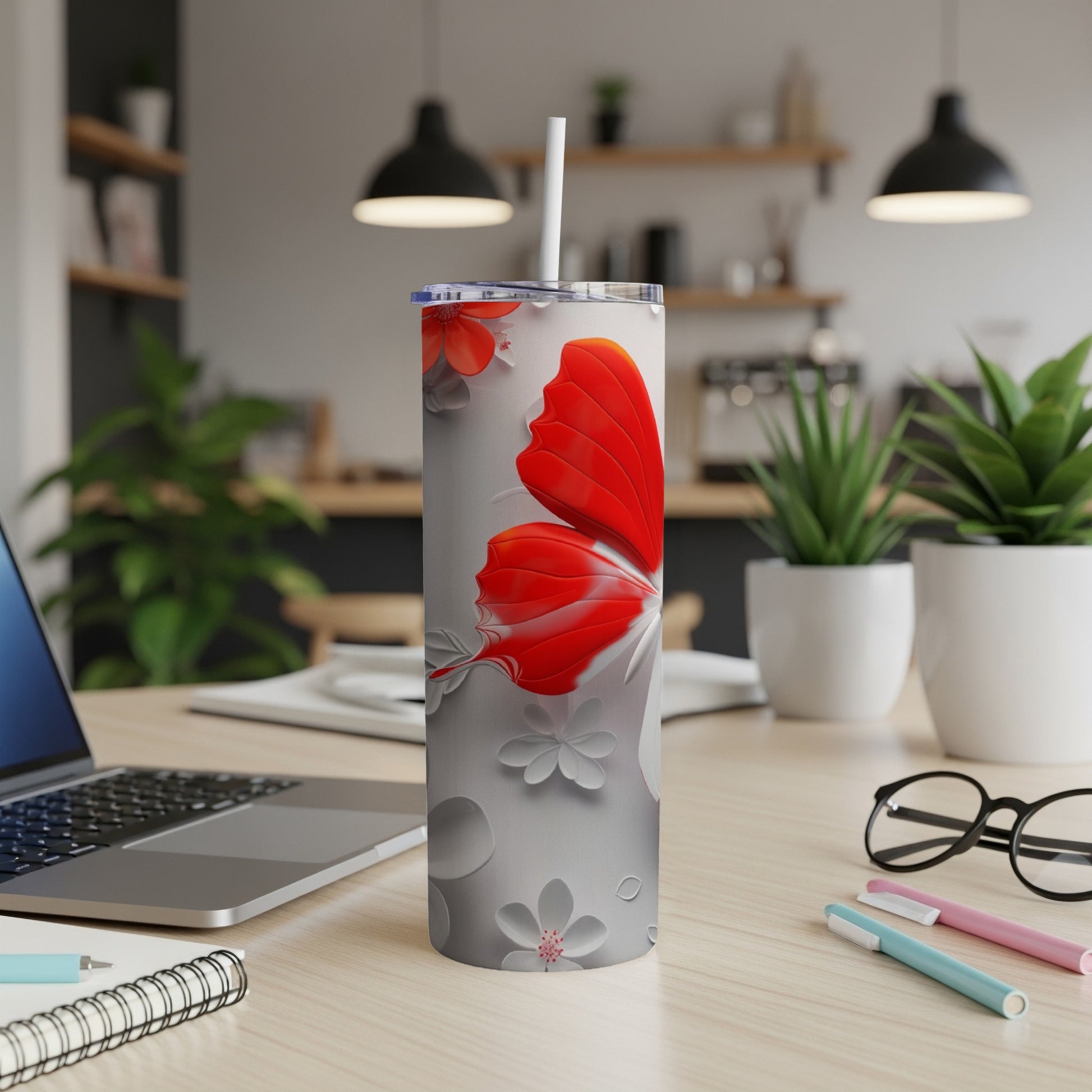 White tumbler with red butterfly and floral design, straw.