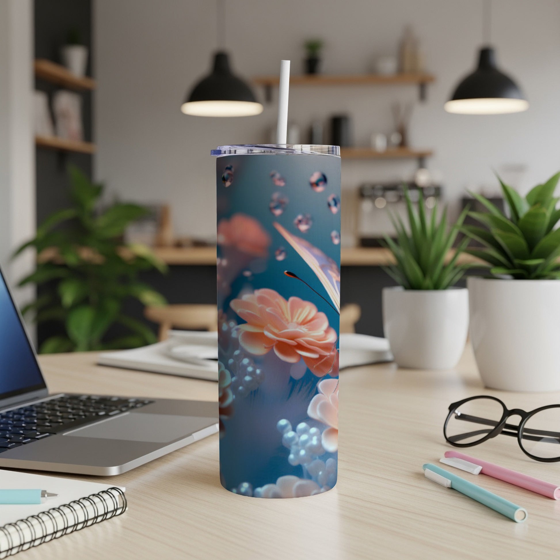 Floral tumbler with butterfly, beads, and water droplets on a desk.