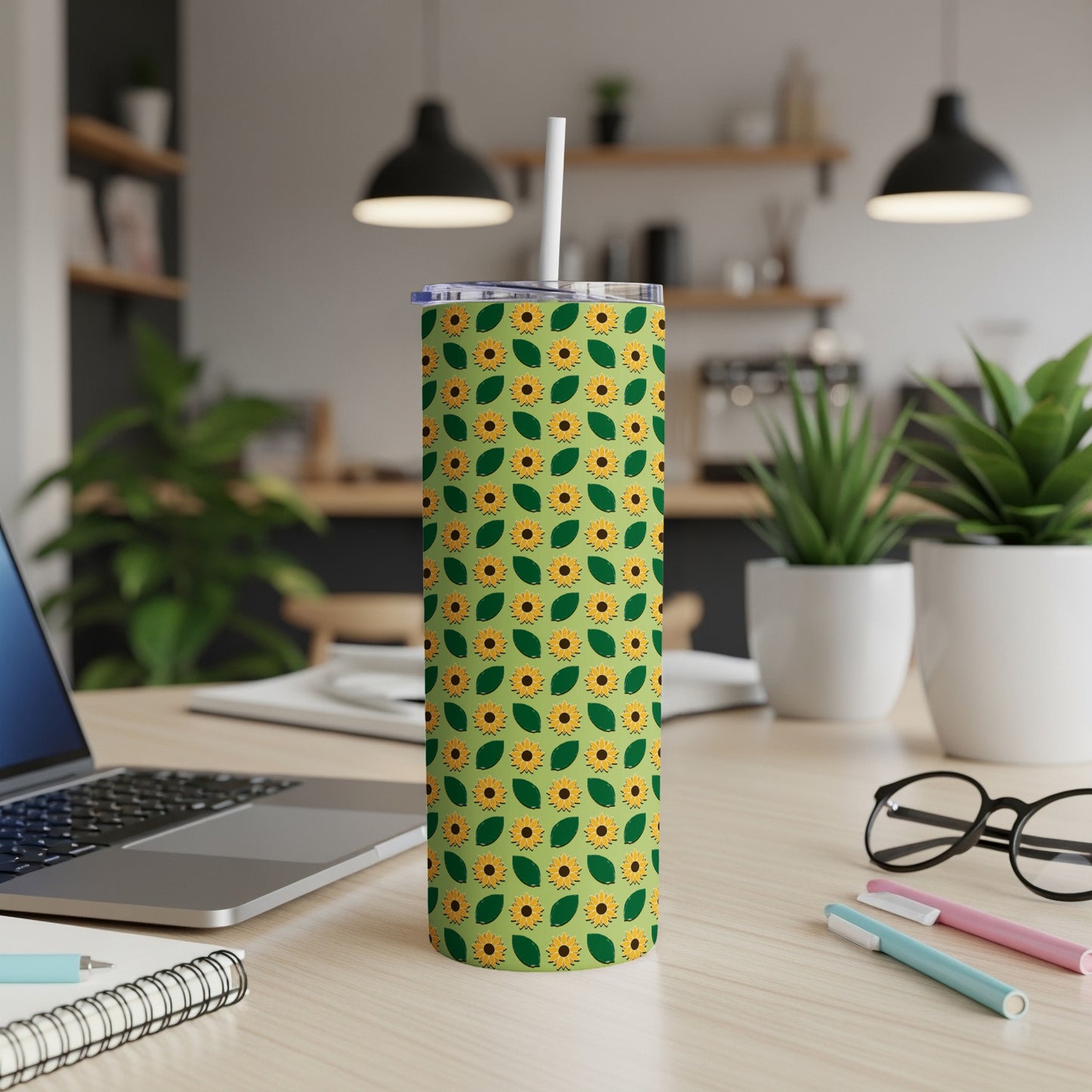 Green tumbler with a repeating sunflower pattern and a white lid and straw.