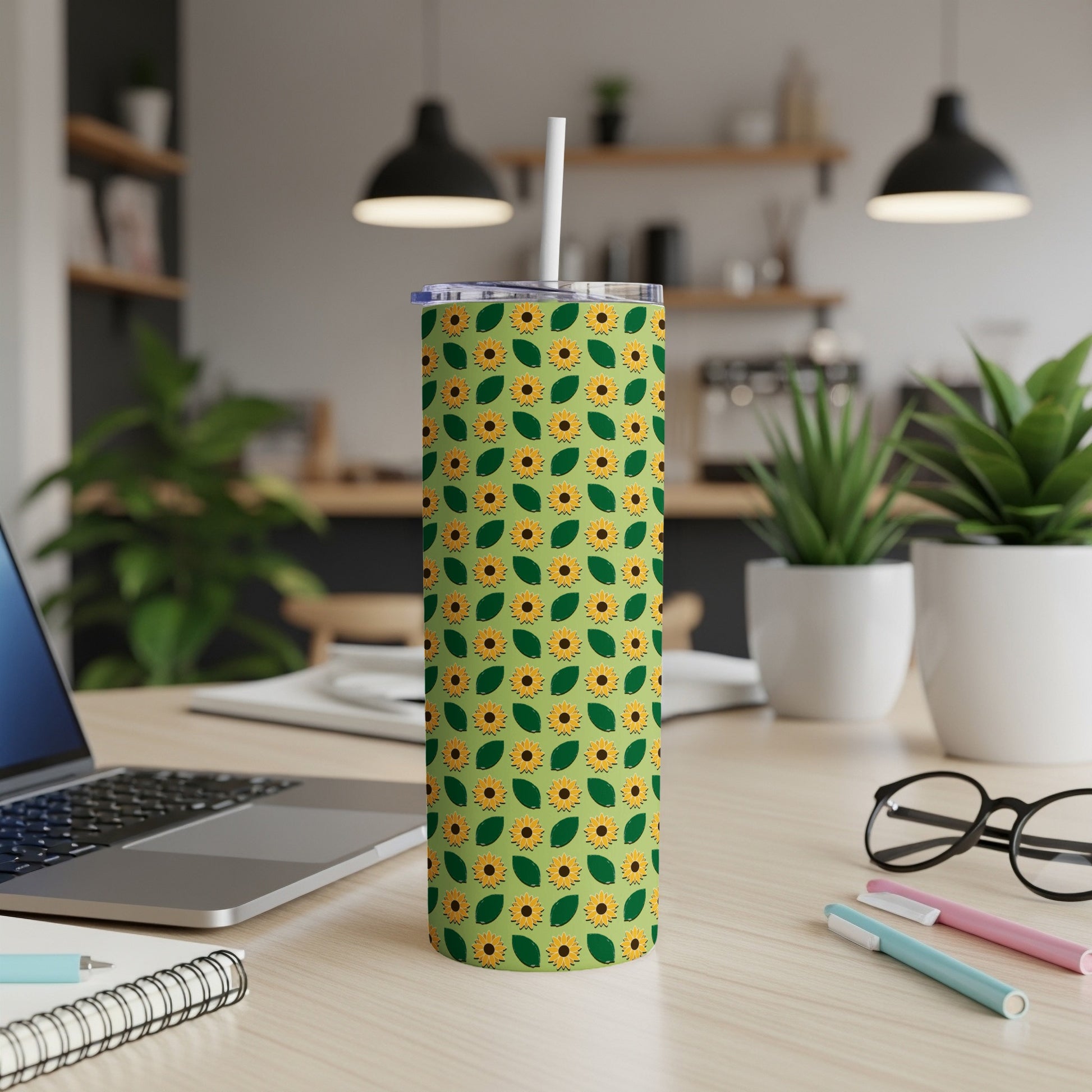 Green tumbler with a repeating sunflower pattern and a white lid and straw.