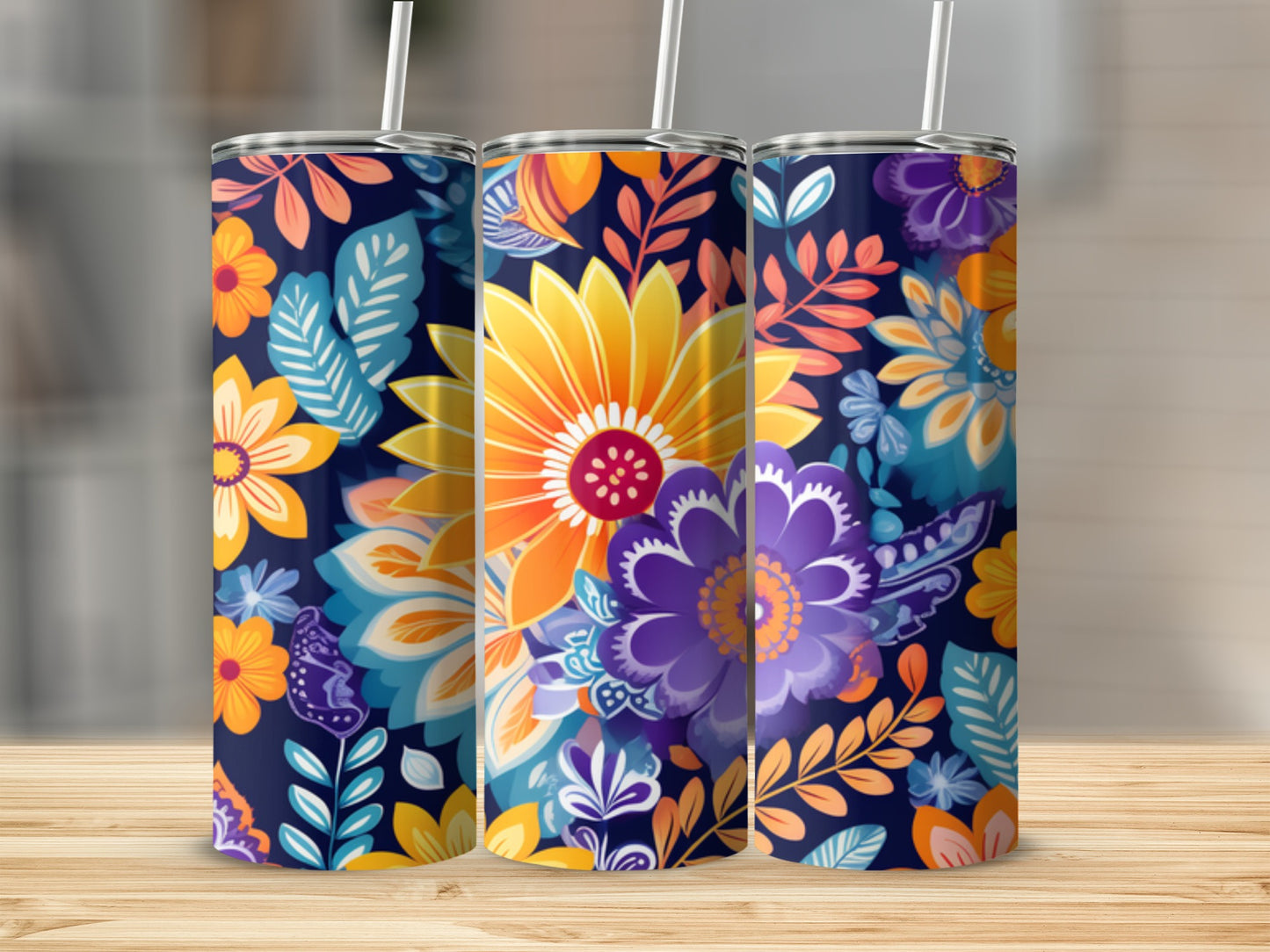 Three tumblers with colorful floral patterns on a wooden surface.