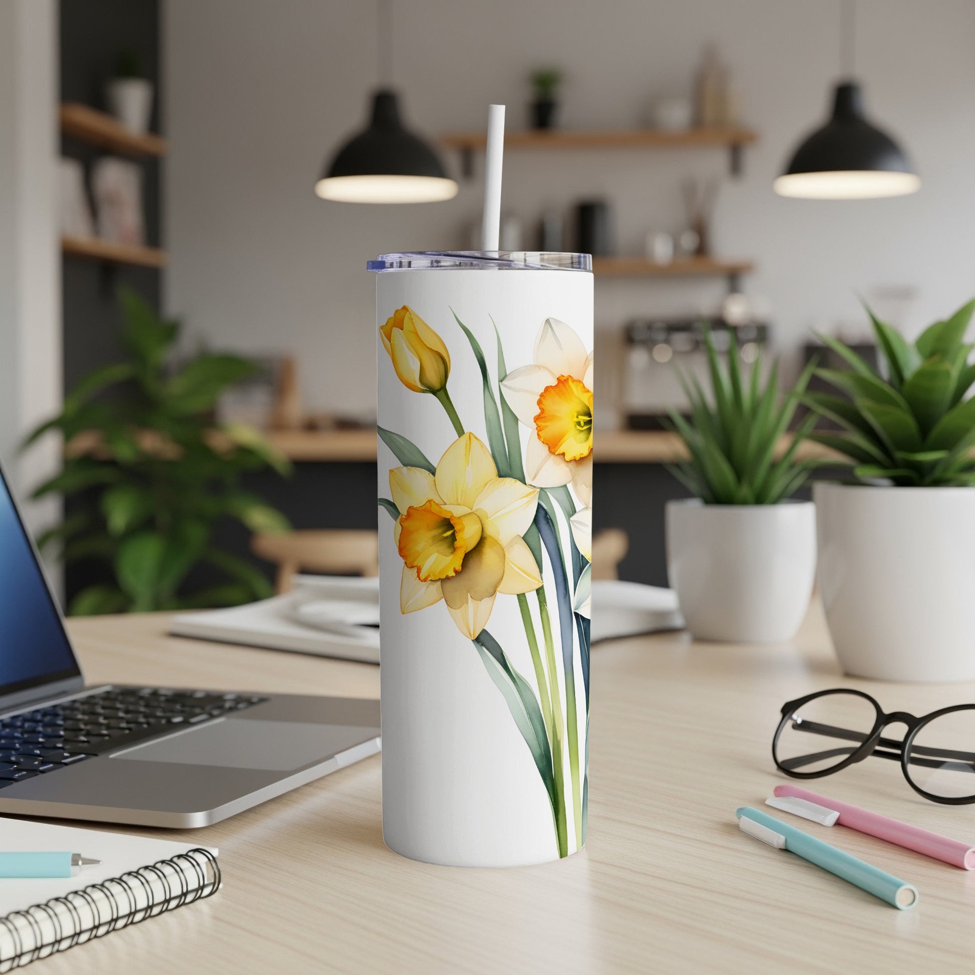White tumbler with watercolor daffodils and green stems.