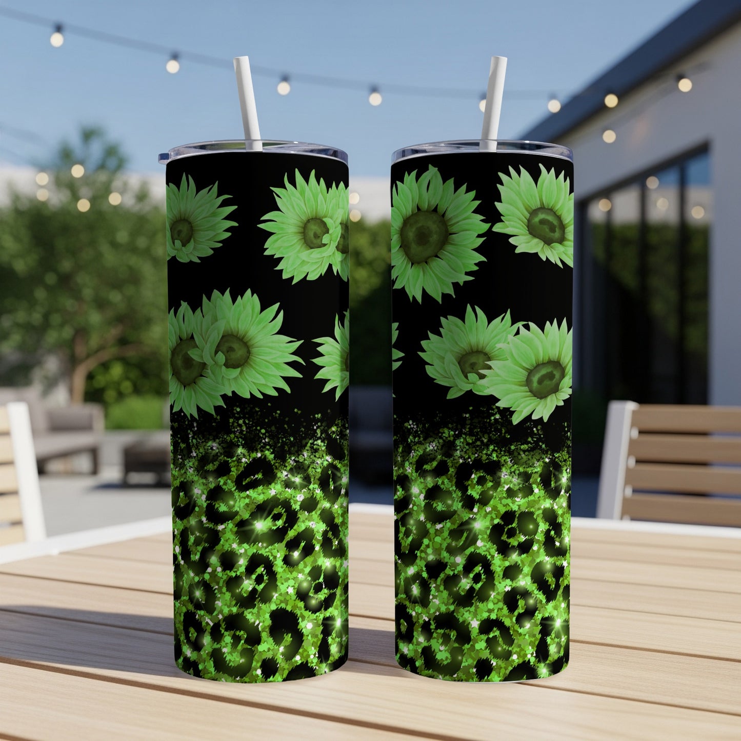 Two green floral tumblers with leopard print on outdoor table.