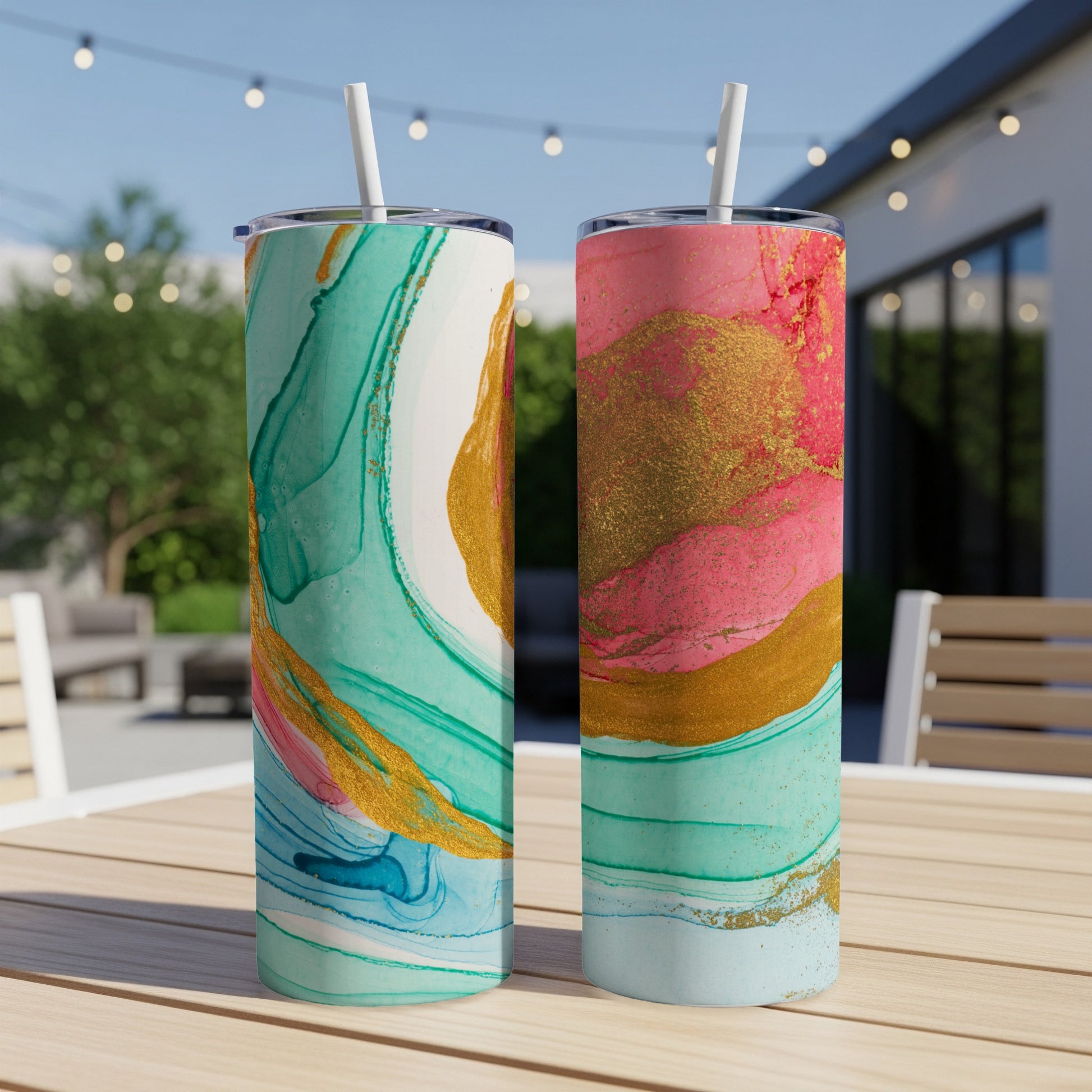 Two tumblers with abstract watercolor designs, one blue-green, one pink.