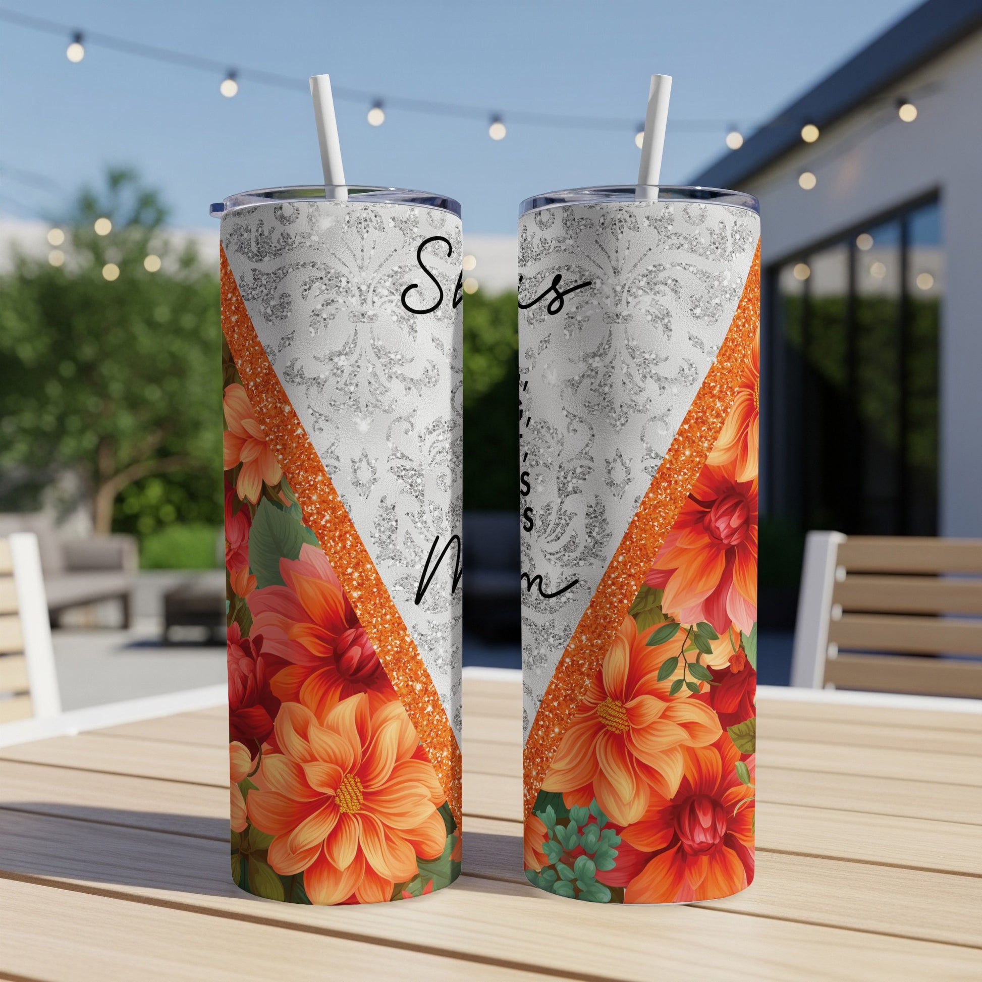 Two tumblers with "Sisters" and floral design on a table.