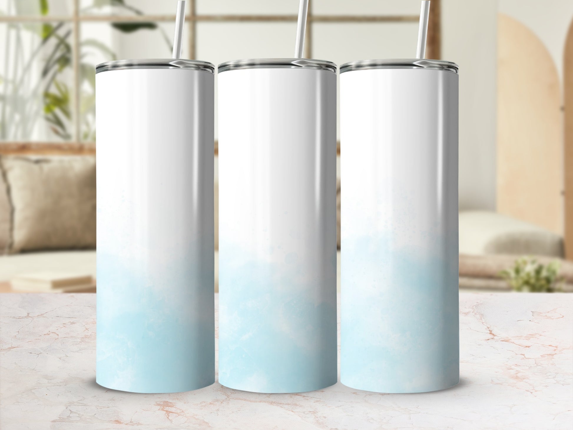 Three blank white tumblers with light blue watercolor accents, standing on a marble surface.