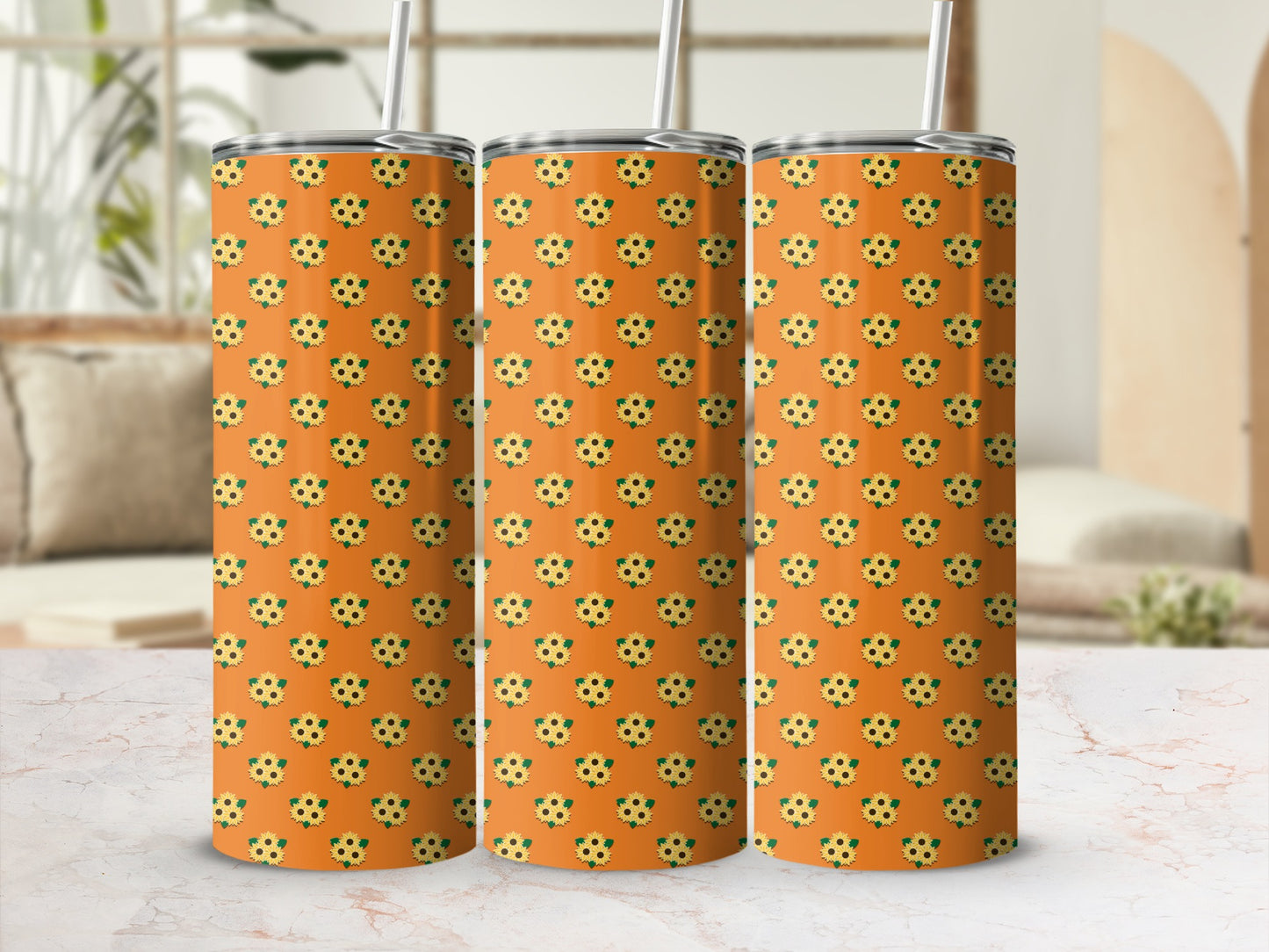 Orange tumbler with a repeating sunflower pattern and straw.