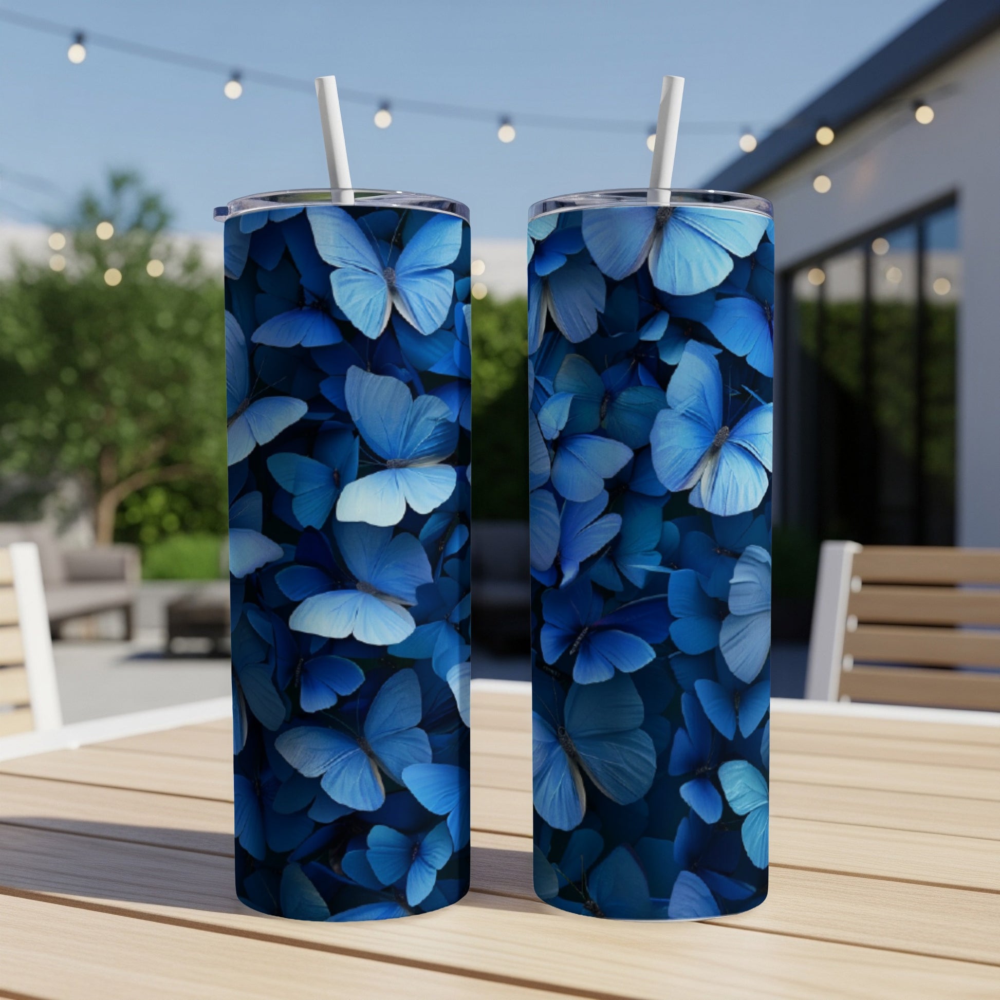 Two blue butterfly patterned tumblers on a wooden table.
