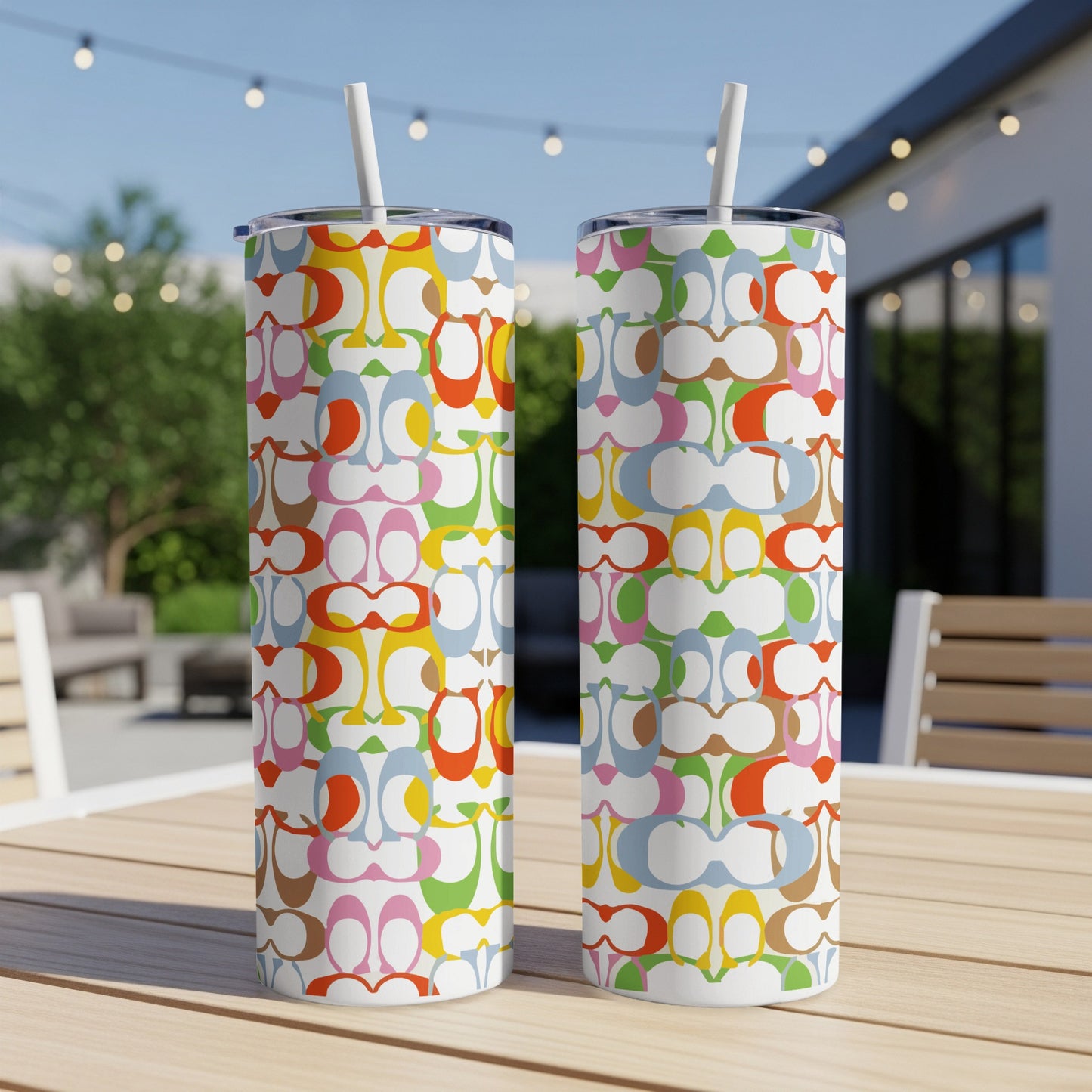 Two tall tumblers with multicolor C-logo pattern and white straws.
