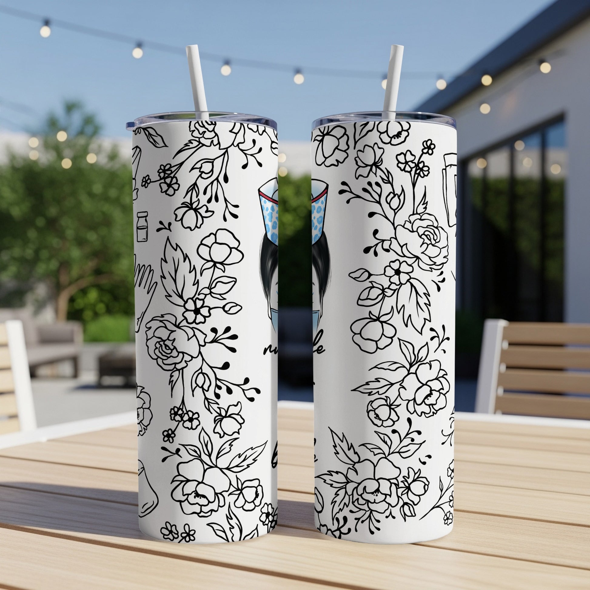 Two white tumblers with floral and medical illustrations, resting on a table.