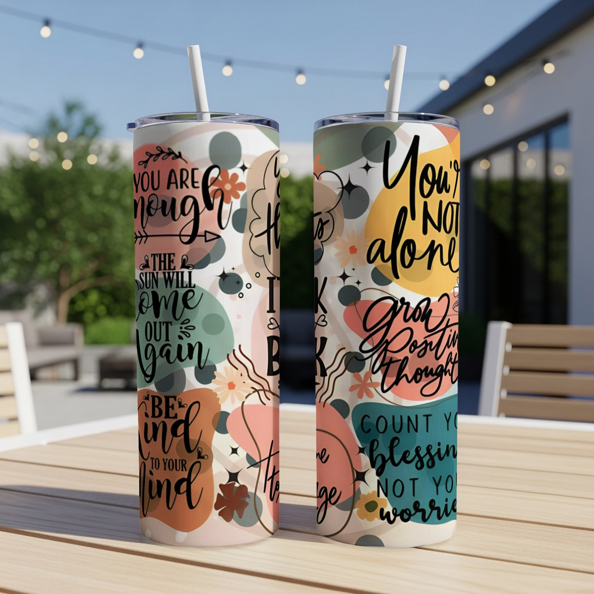 Two tumblers with floral patterns and motivational quotes.