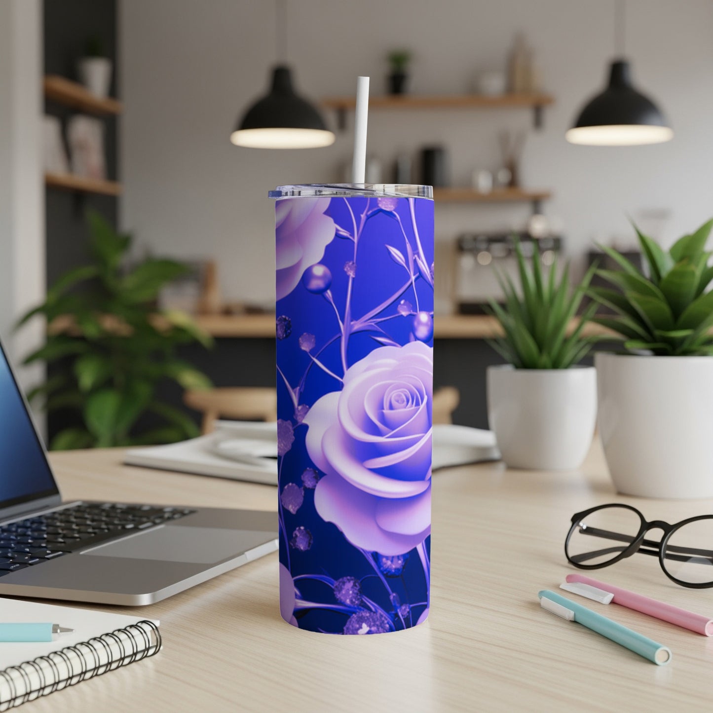 Purple rose tumbler with straw on a wooden desk next to a laptop.