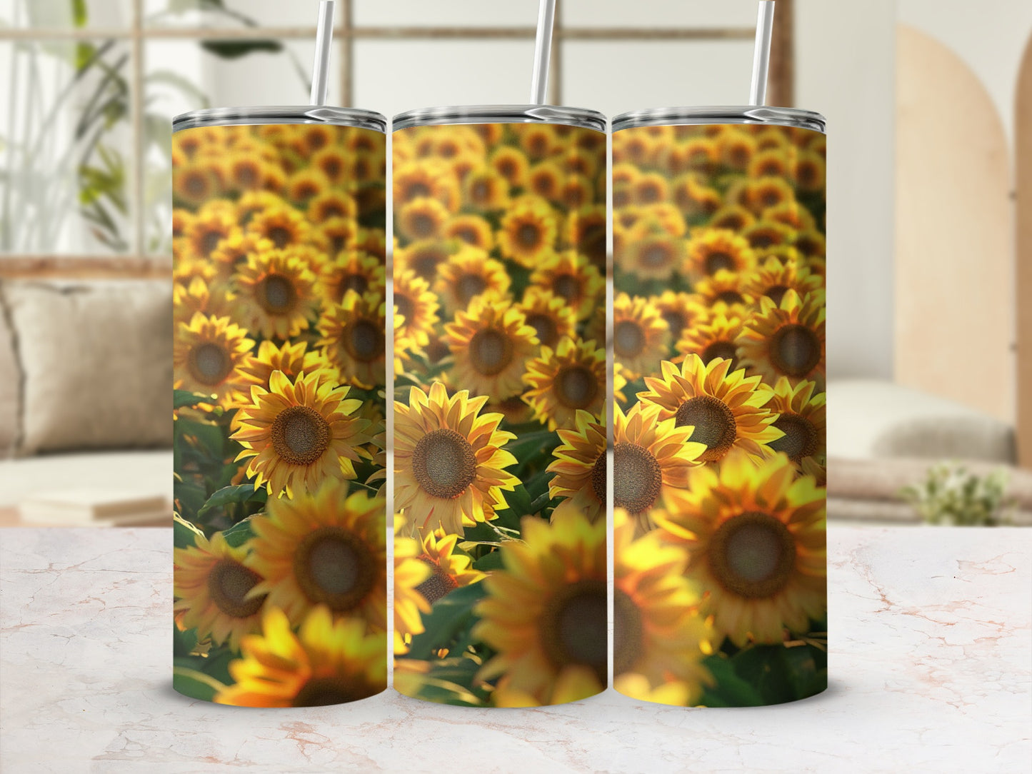 Three tumblers with a sunflower pattern sit on a marble surface.
