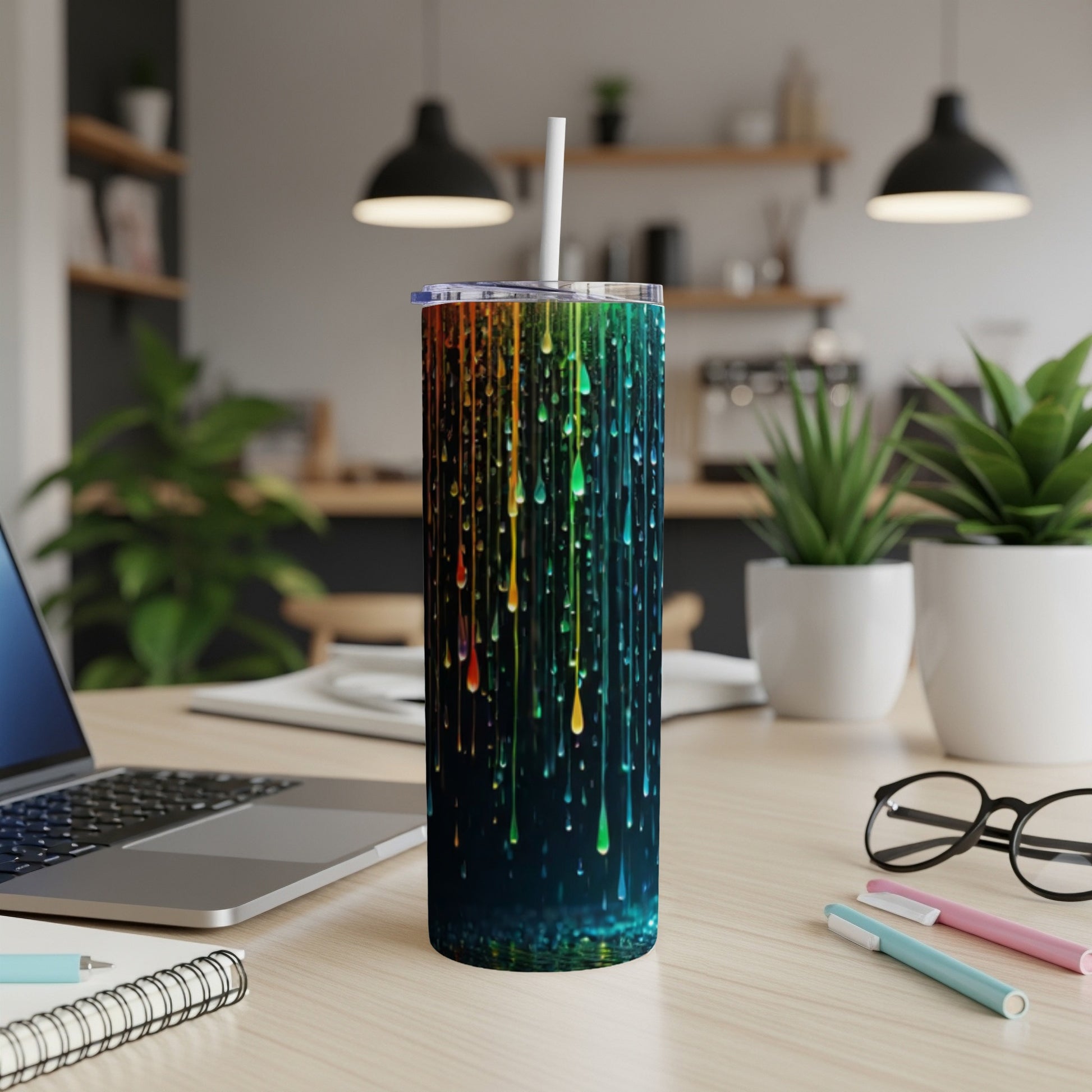 Colorful dripping paint design on a dark tumbler with a straw.