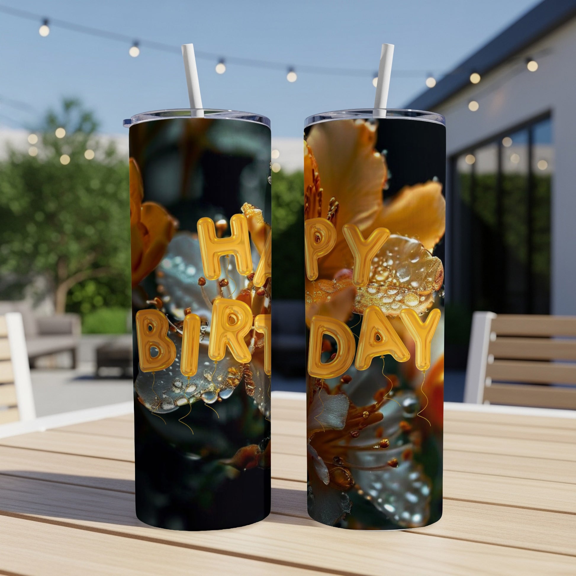 Two tumblers with "Happy Birthday" text and floral design on a table.