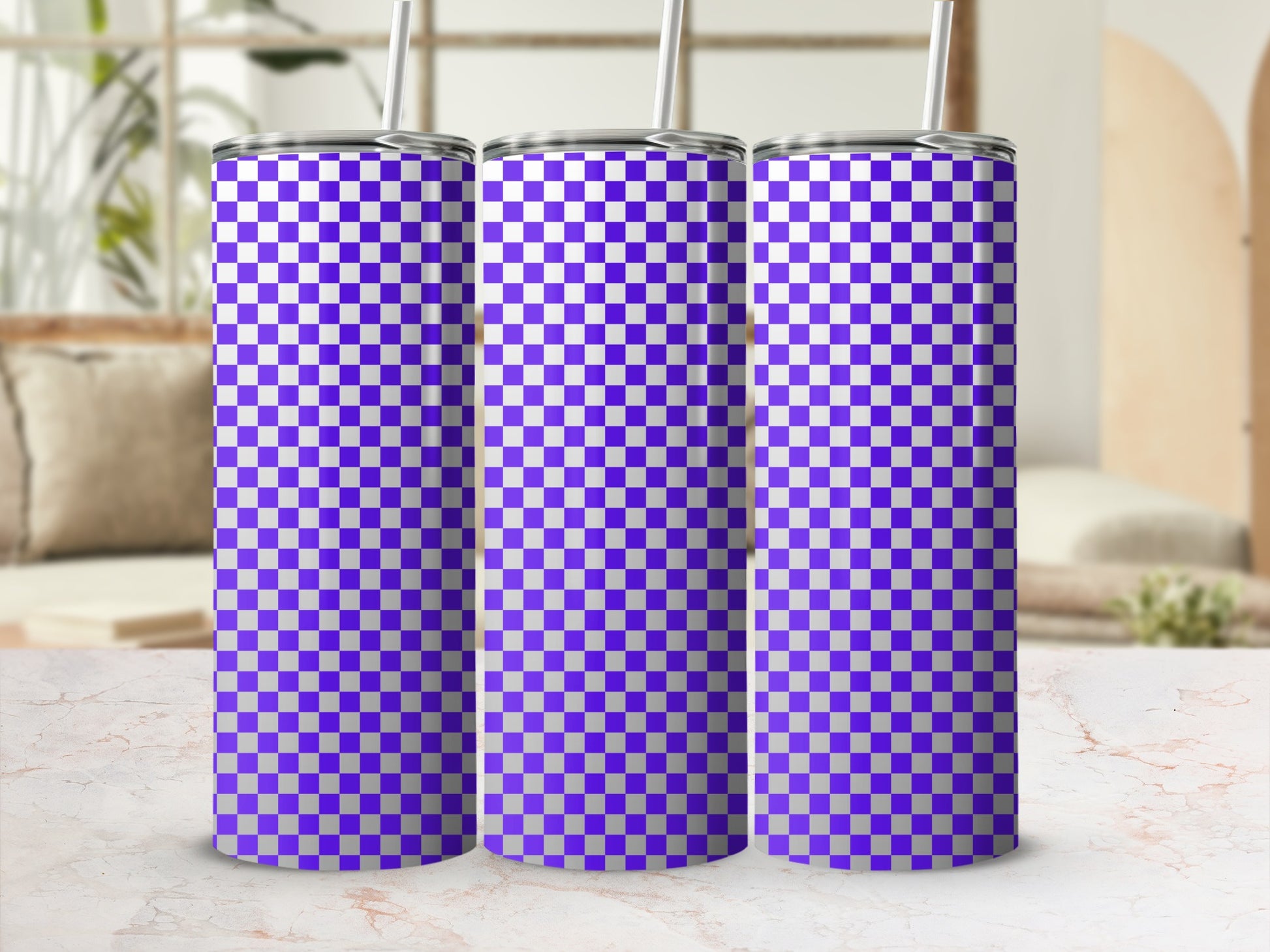 Three purple and white checkered tumblers with straws on a marble surface.