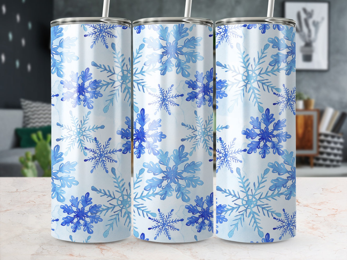 Three tumblers with blue watercolor snowflakes on white background.