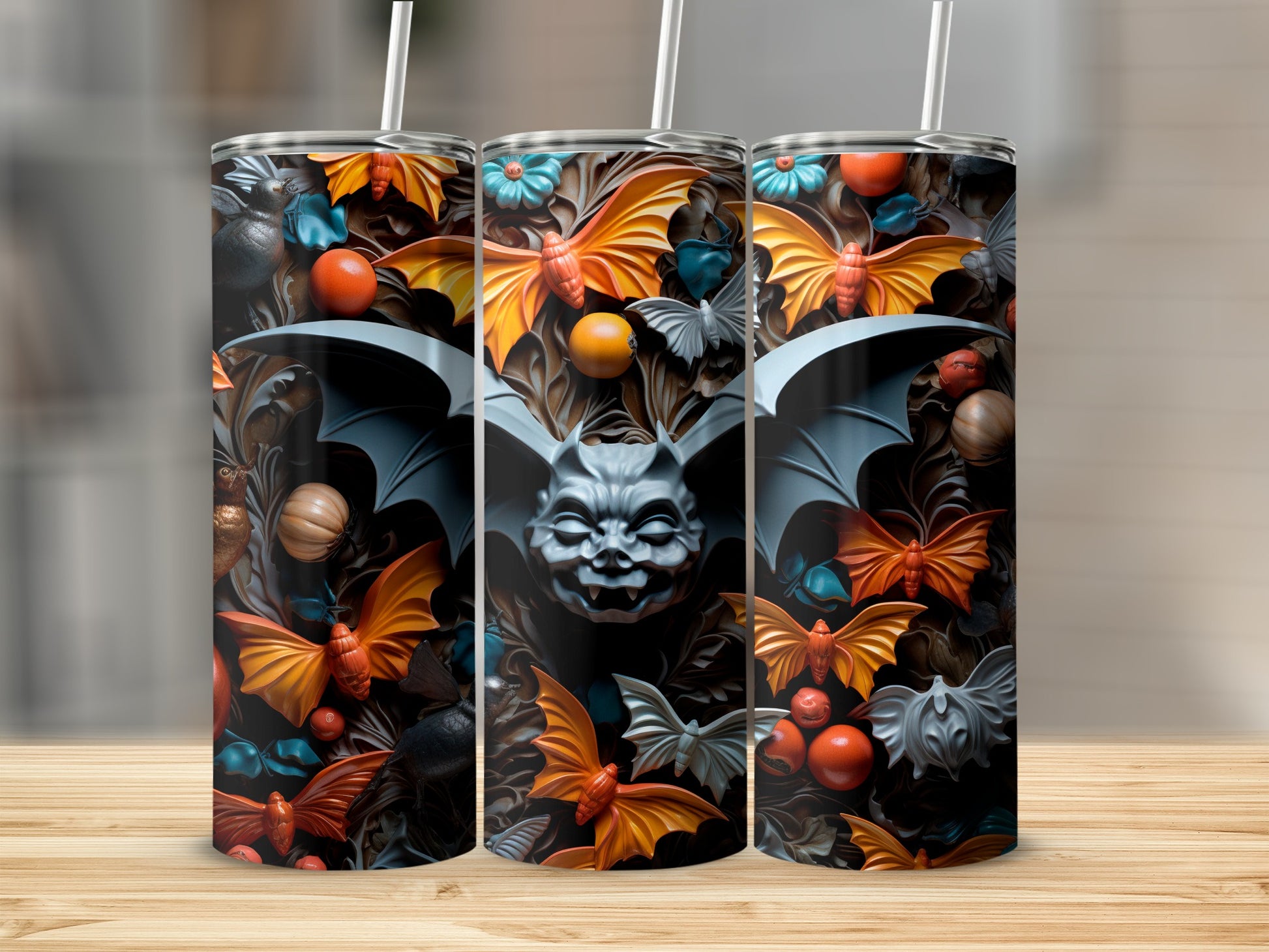 Three tumblers with a Halloween-themed design featuring bats, pumpkins, and floral elements.